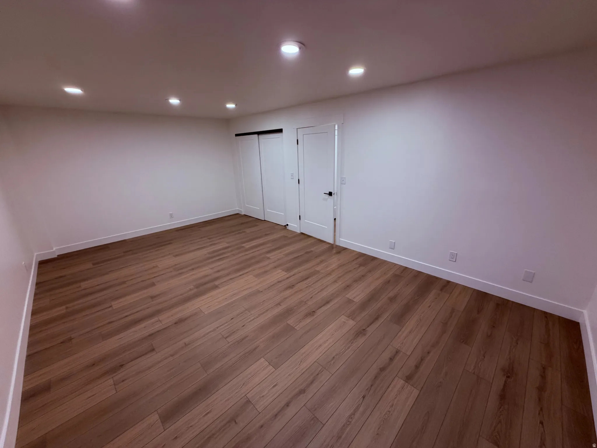 Below grade area with dark wood-style floors and recessed lighting