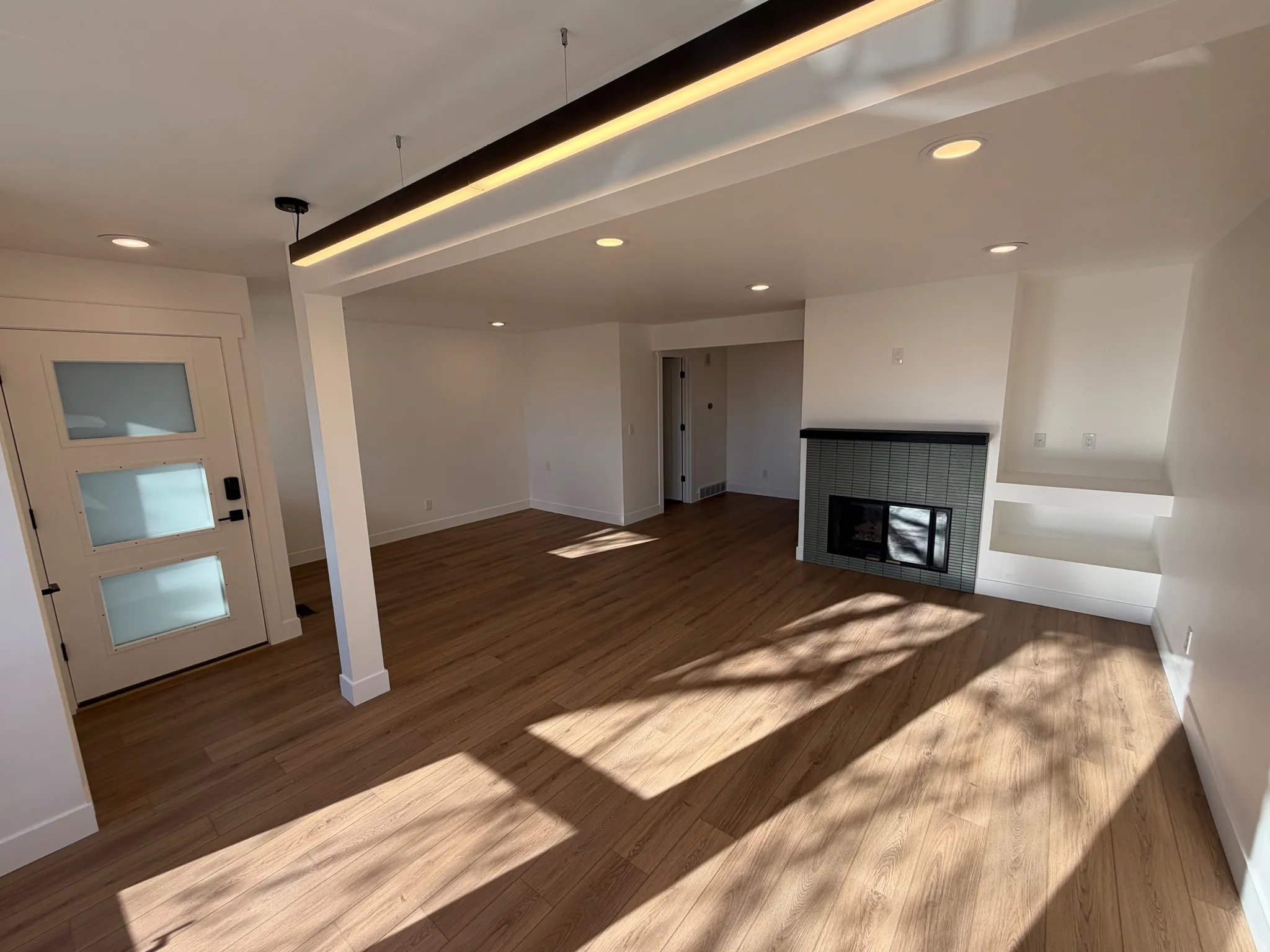 Unfurnished living room with recessed lighting, a multi sided fireplace, and dark wood-style flooring