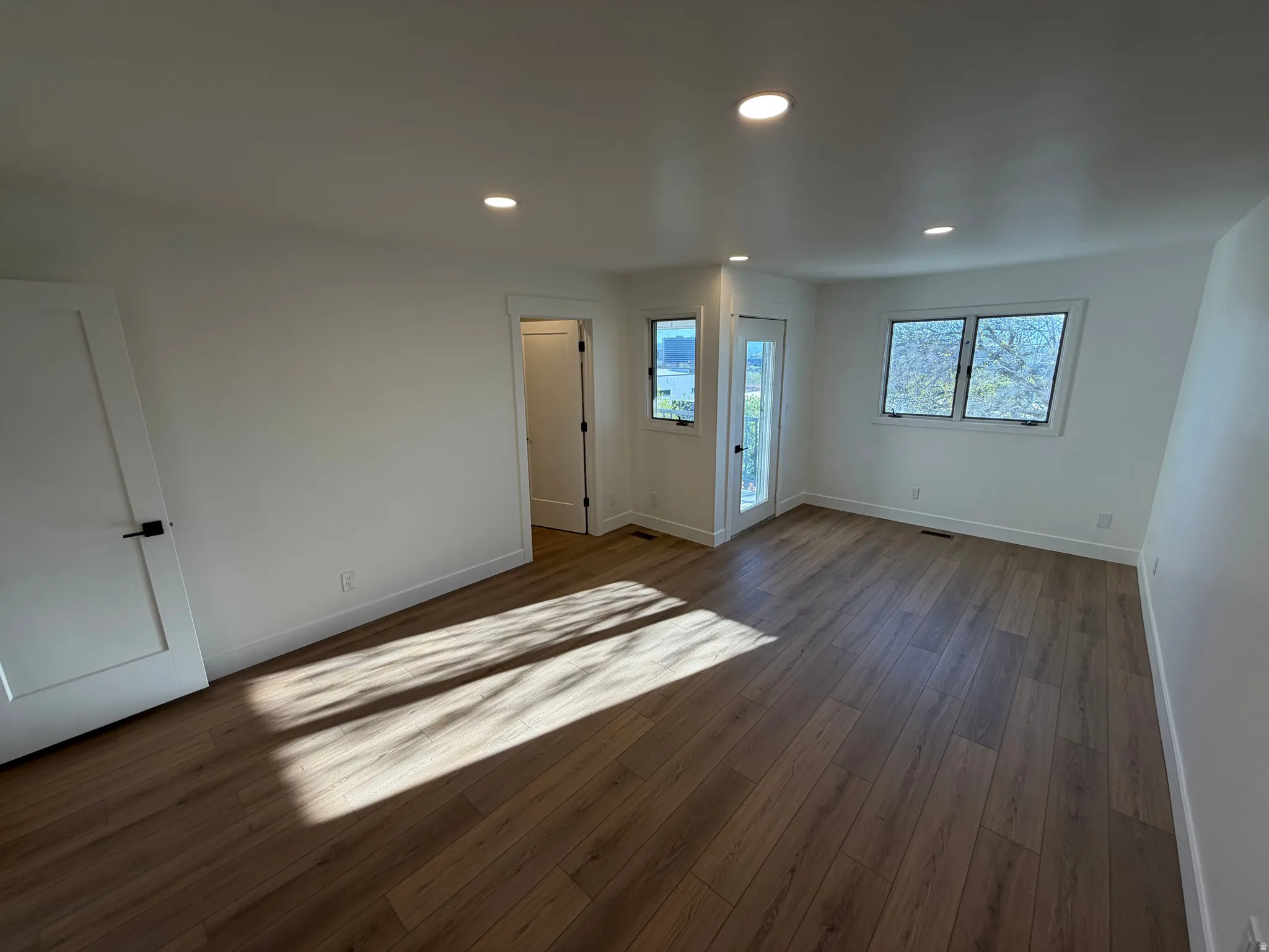 Unfurnished bedroom featuring access to outside, recessed lighting, and dark wood-style floors