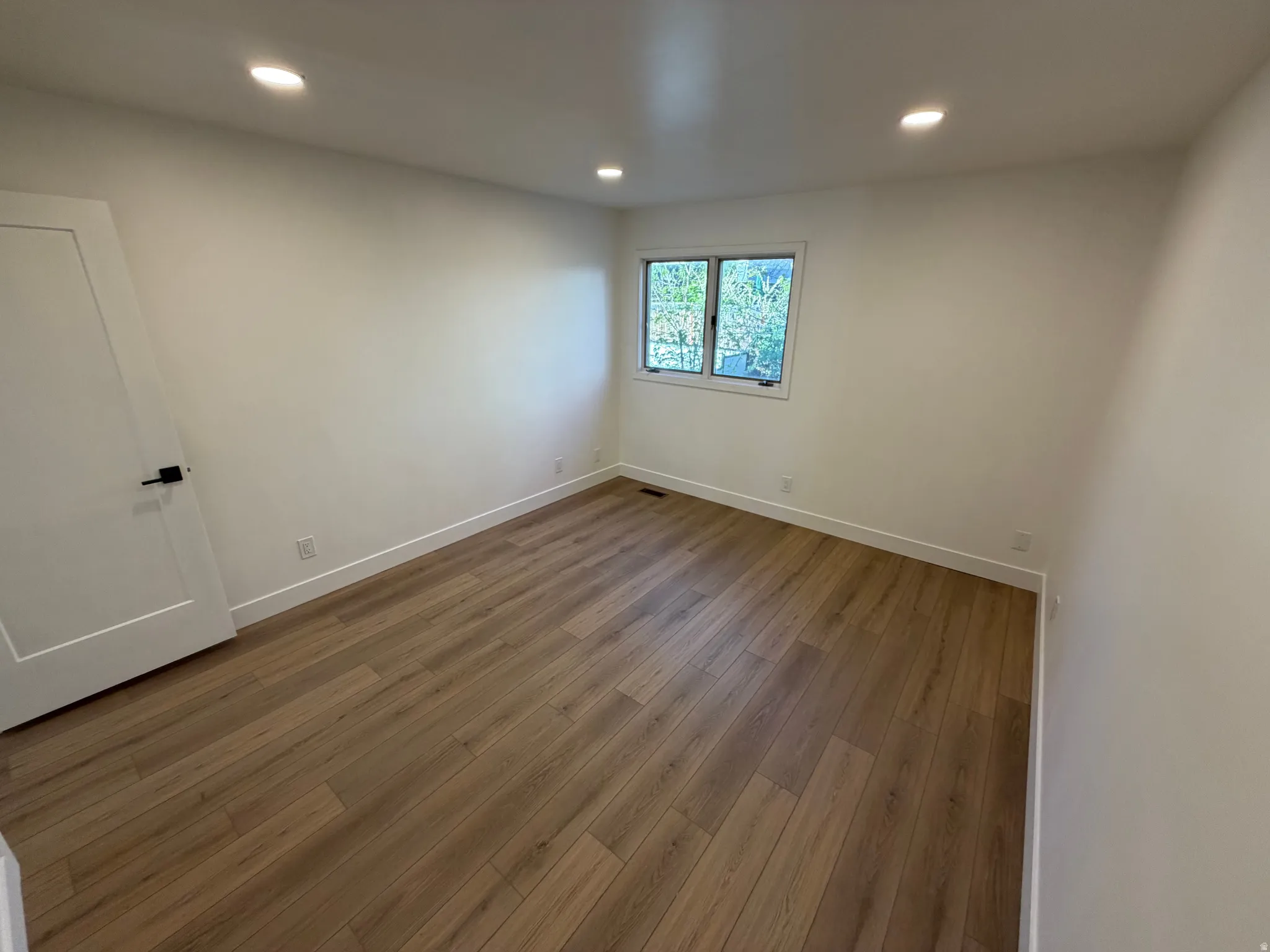 Spare room featuring dark wood-style floors and recessed lighting