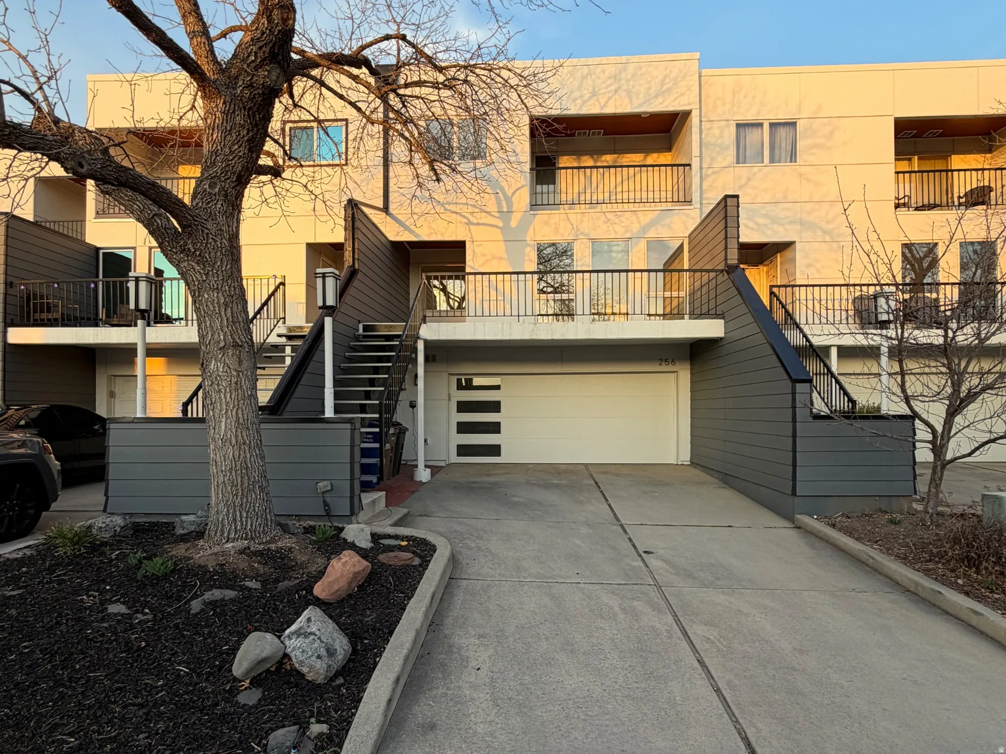 View of front of house with concrete driveway, an attached garage, and stucco siding