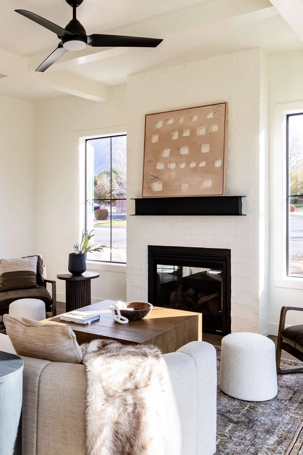 Living area with a brick fireplace, a ceiling fan, and healthy amount of natural light