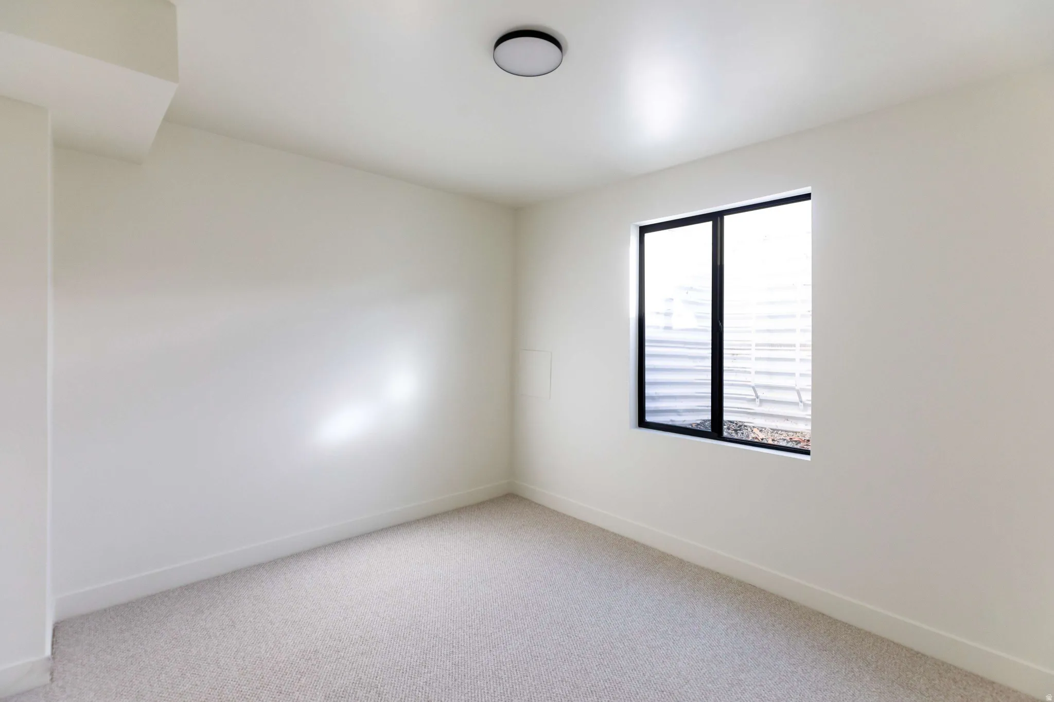 Spare room with light carpet and baseboards