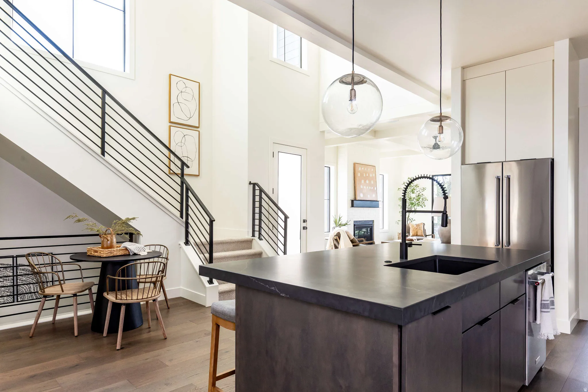 Kitchen featuring plenty of natural light, modern cabinets, dark countertops, and a high ceiling