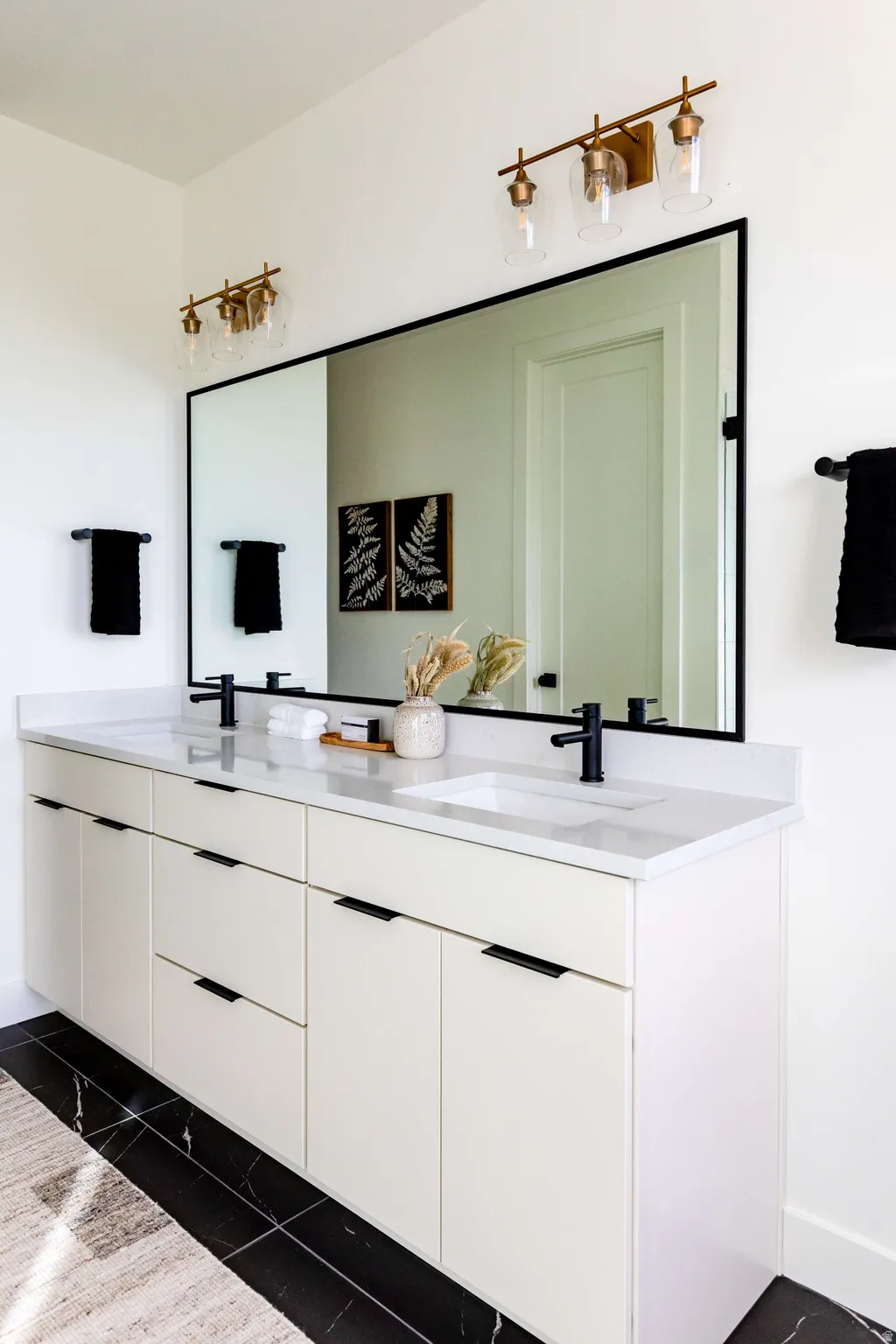 Bathroom featuring double vanity and baseboards