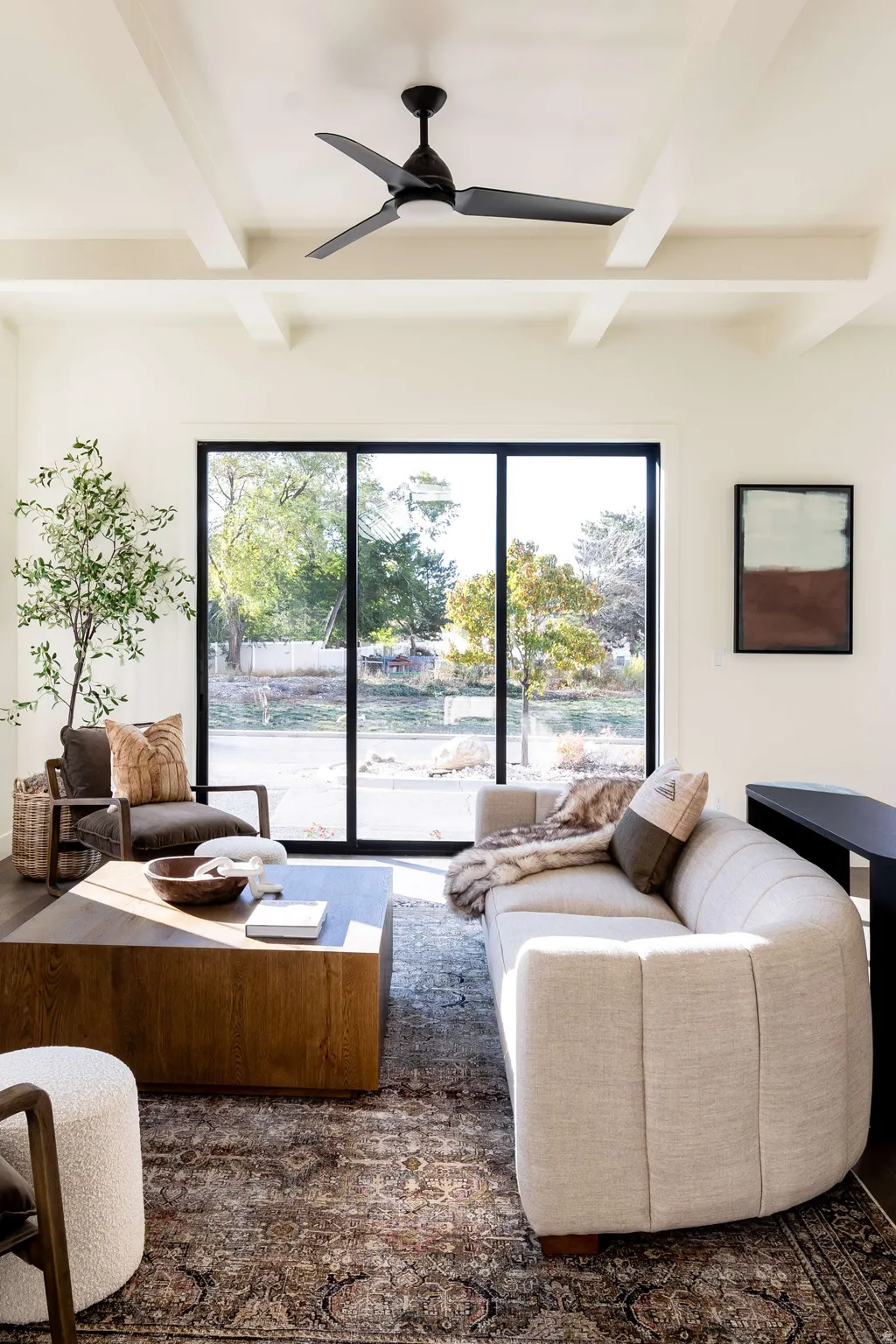 Living room featuring ceiling fan and coffered ceiling