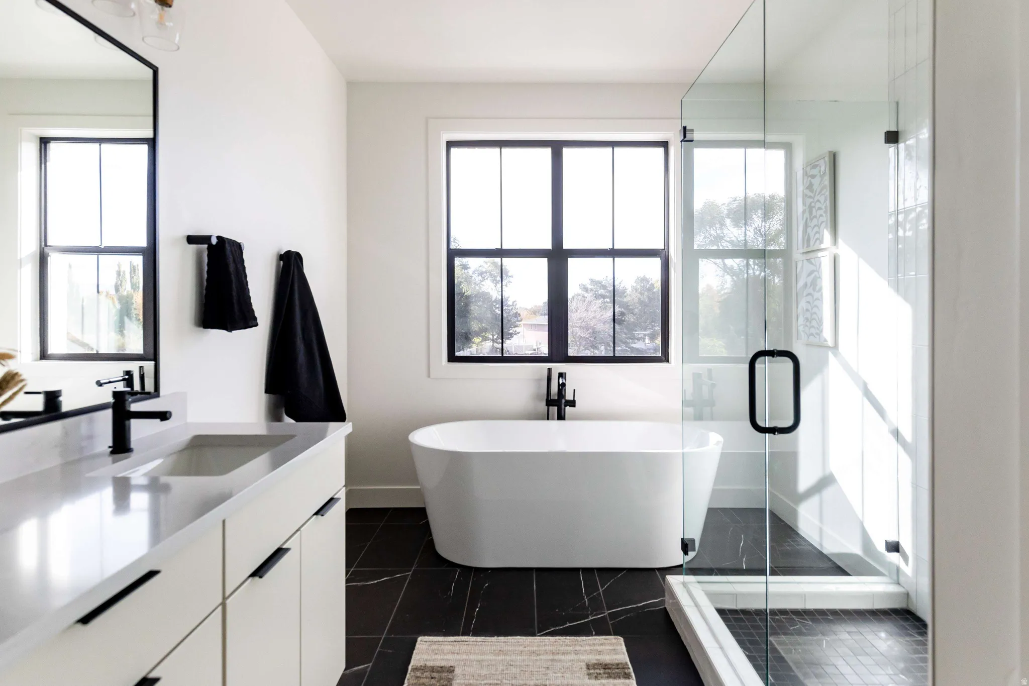 Full bathroom with vanity, a shower stall, a soaking tub, and healthy amount of natural light