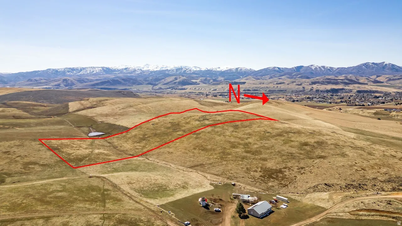 Overview of rural landscape with a mountainous background and property parcel outlined