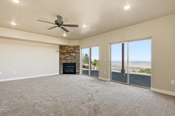 Unfurnished living room with ceiling fan, carpet, a fireplace, and recessed lighting