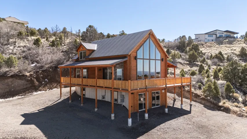 Back of house featuring a deck and a metal roof