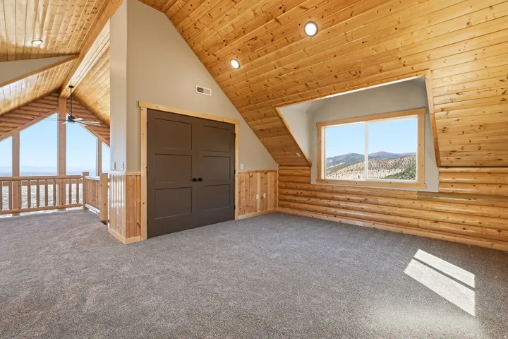 Additional living space with carpet flooring, wooden ceiling, recessed lighting, rustic walls, and ceiling fan