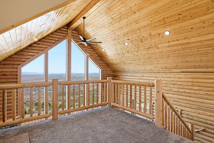 Additional living space featuring log walls, healthy amount of natural light, wood ceiling, a ceiling fan, and recessed lighting