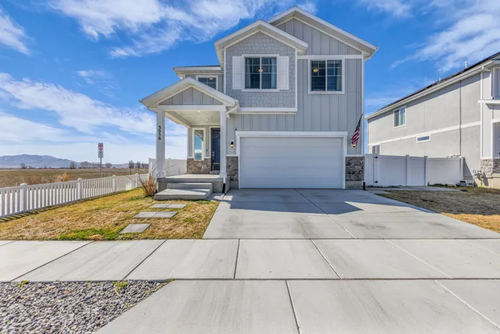 Craftsman inspired home featuring board and batten siding, a mountain view, stone siding, driveway, and a garage