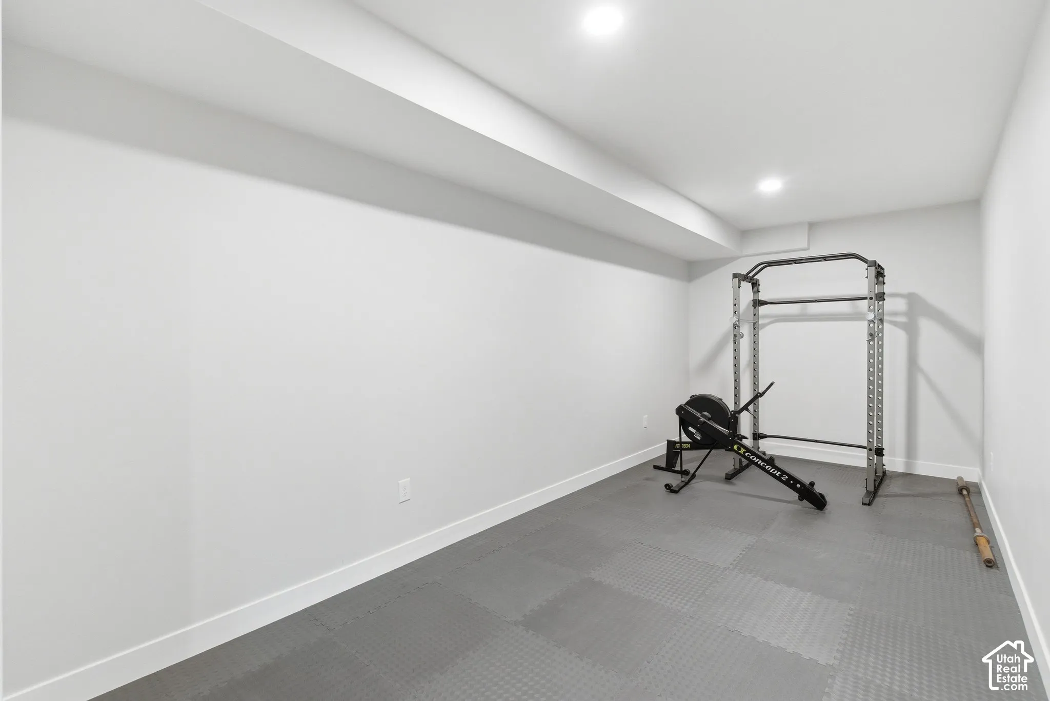 Large flex space currently set up as a workout room with recessed lighting and rubber floors