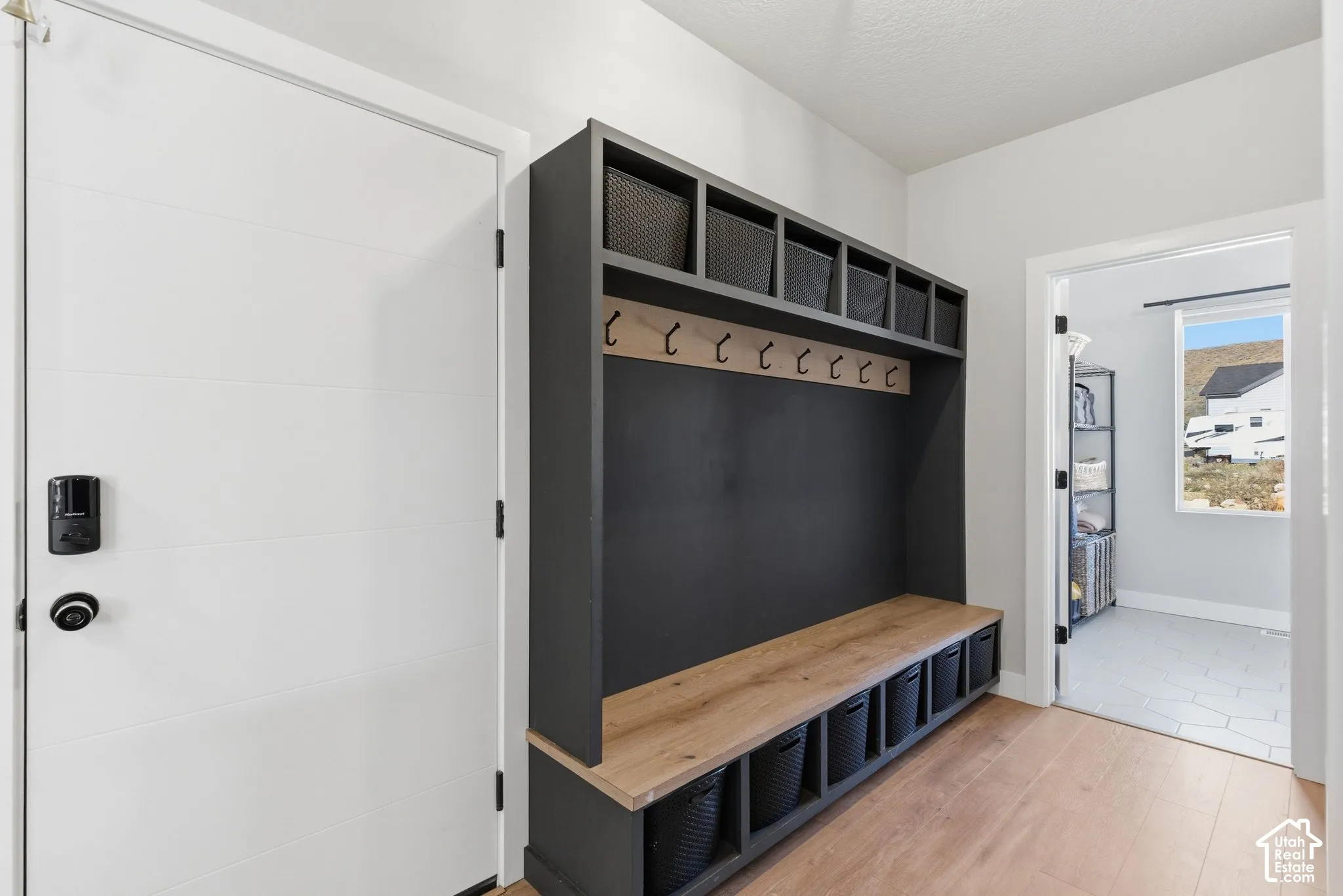 Mudroom featuring light wood-type flooring and baseboards; this property has ample storage throughout