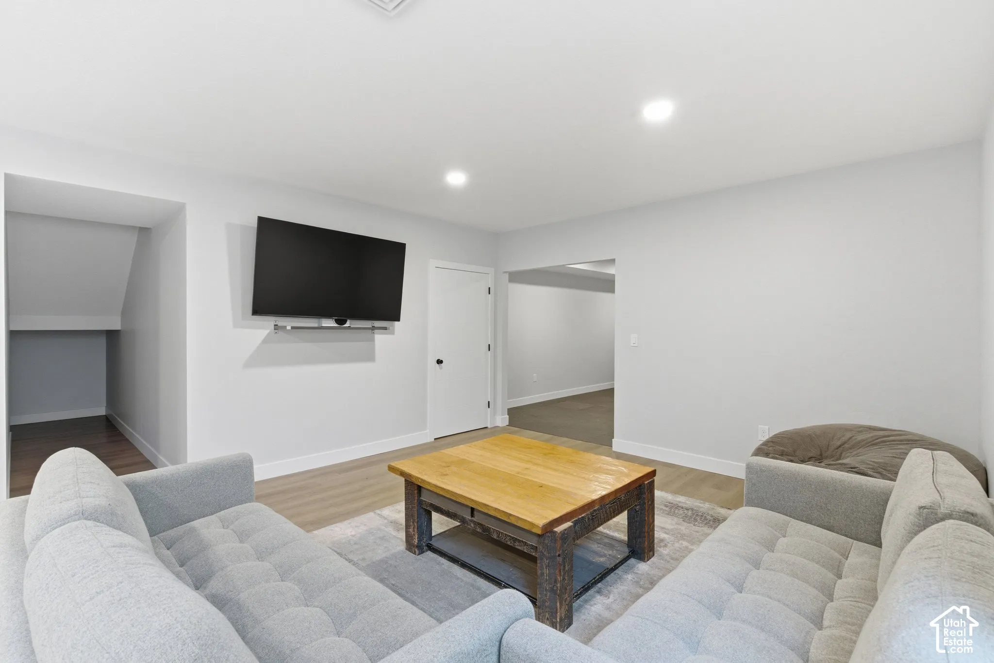 Living room with light wood-type flooring and recessed lighting