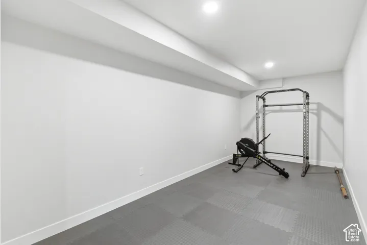 Large flex space currently set up as a workout room with recessed lighting and rubber floors
