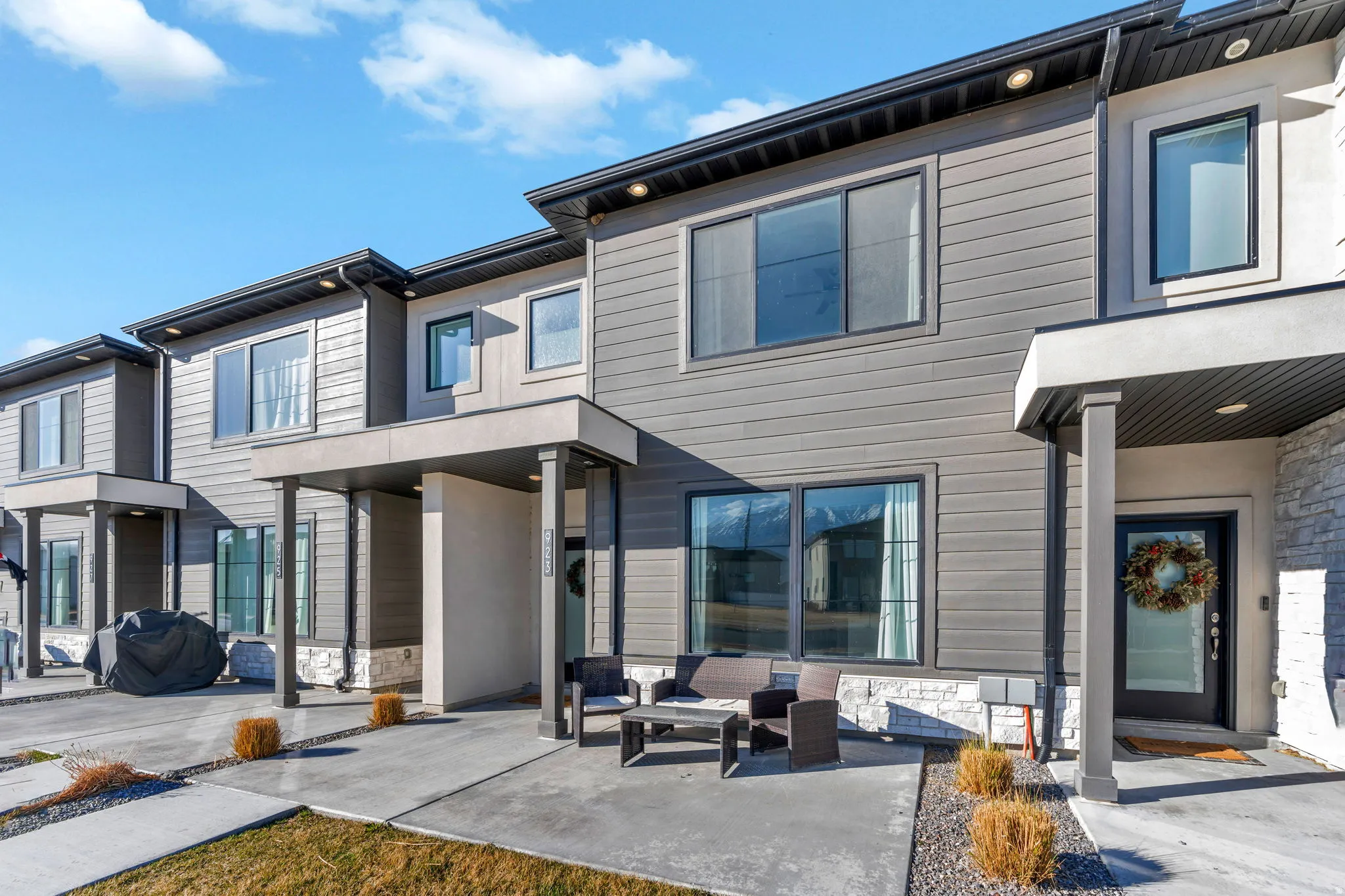 View of front of property with stone siding, a patio, and an outdoor hangout area