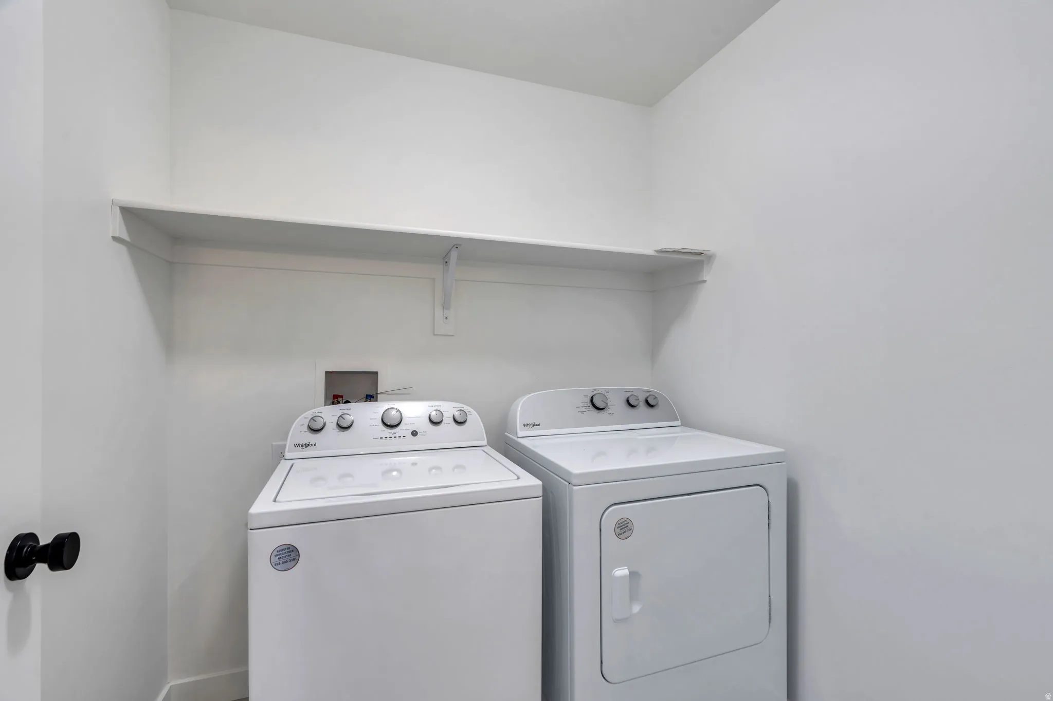 Laundry room with washer and clothes dryer and baseboards