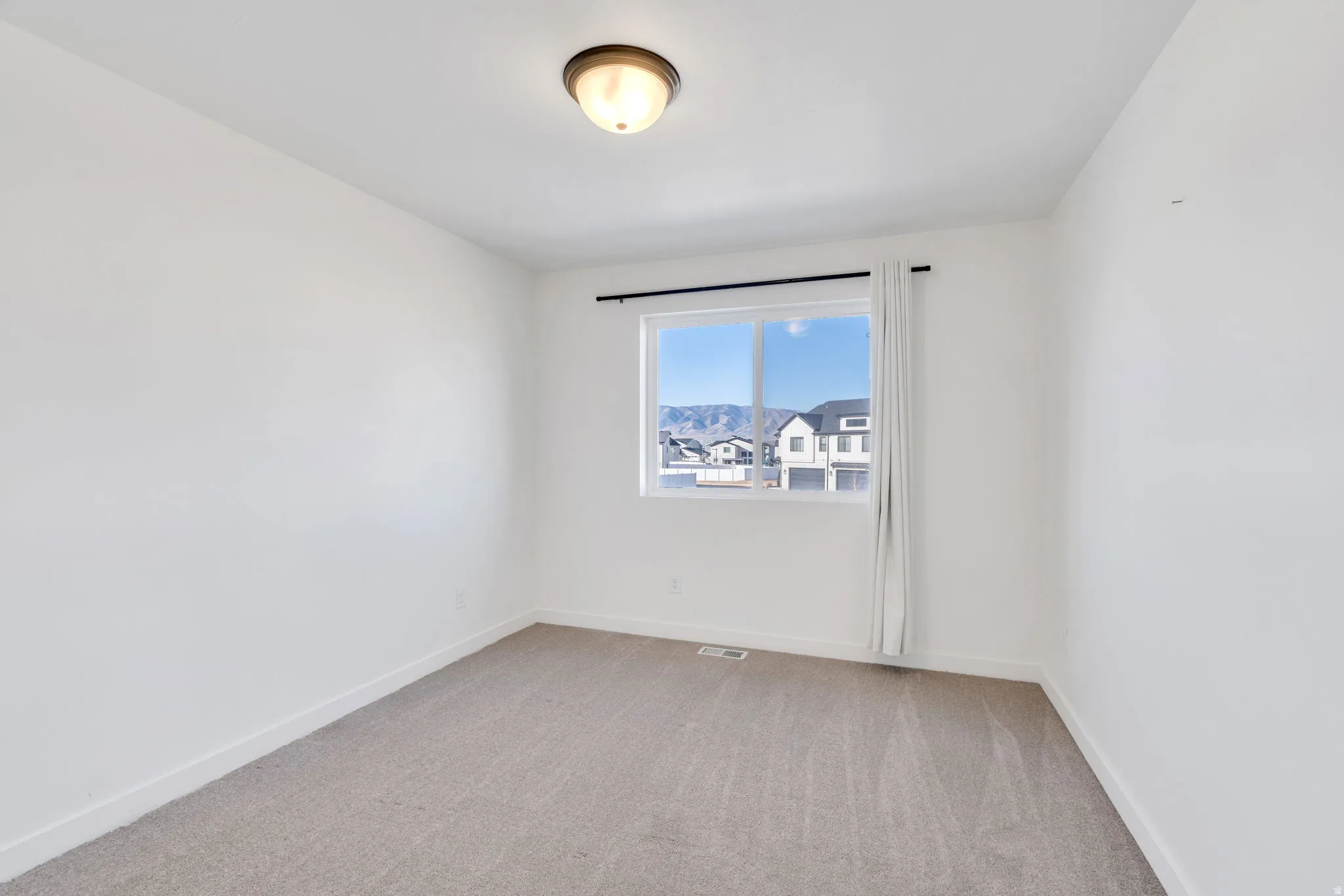Unfurnished room featuring light carpet and baseboards