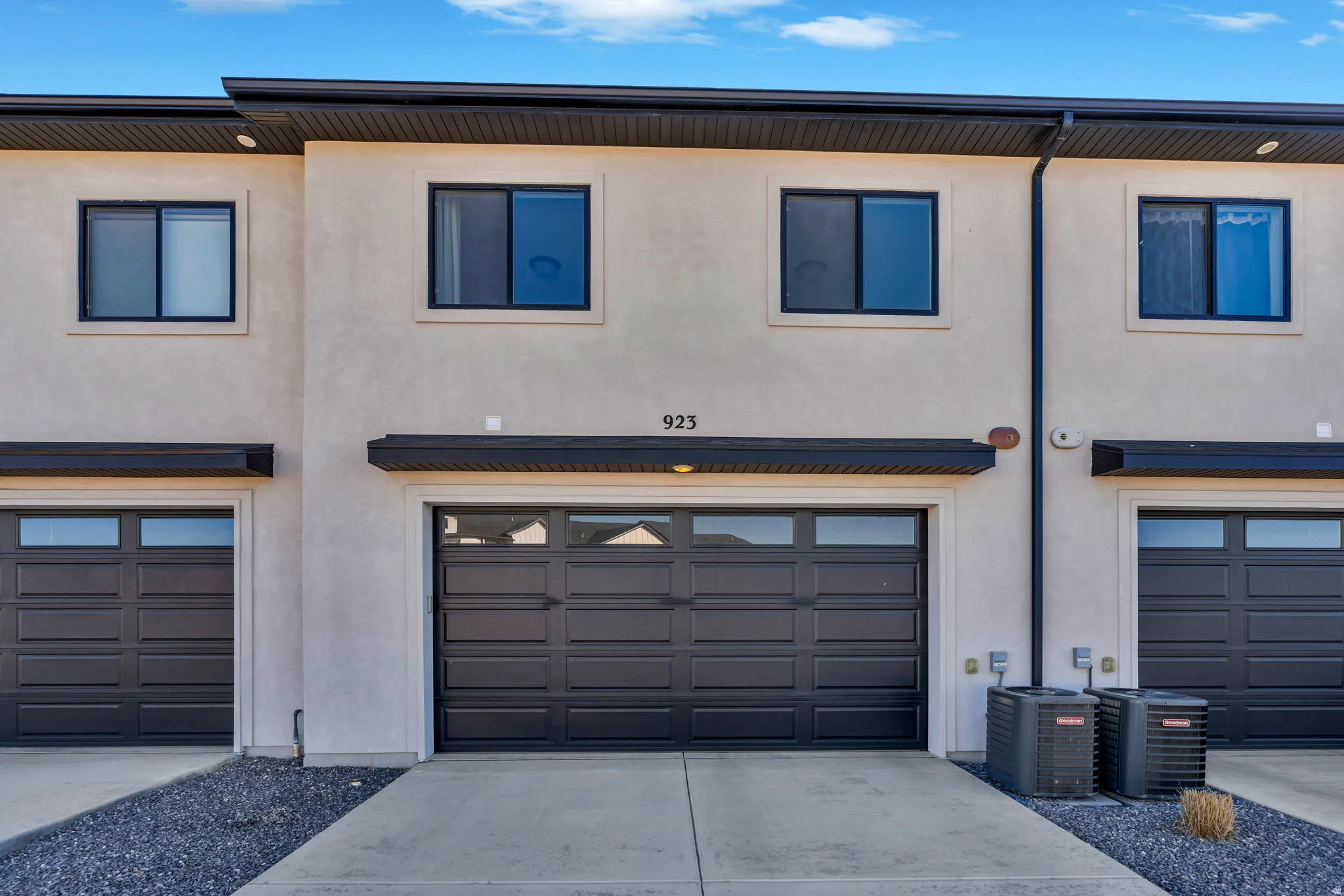 View of front of home with stucco siding, a garage, and driveway