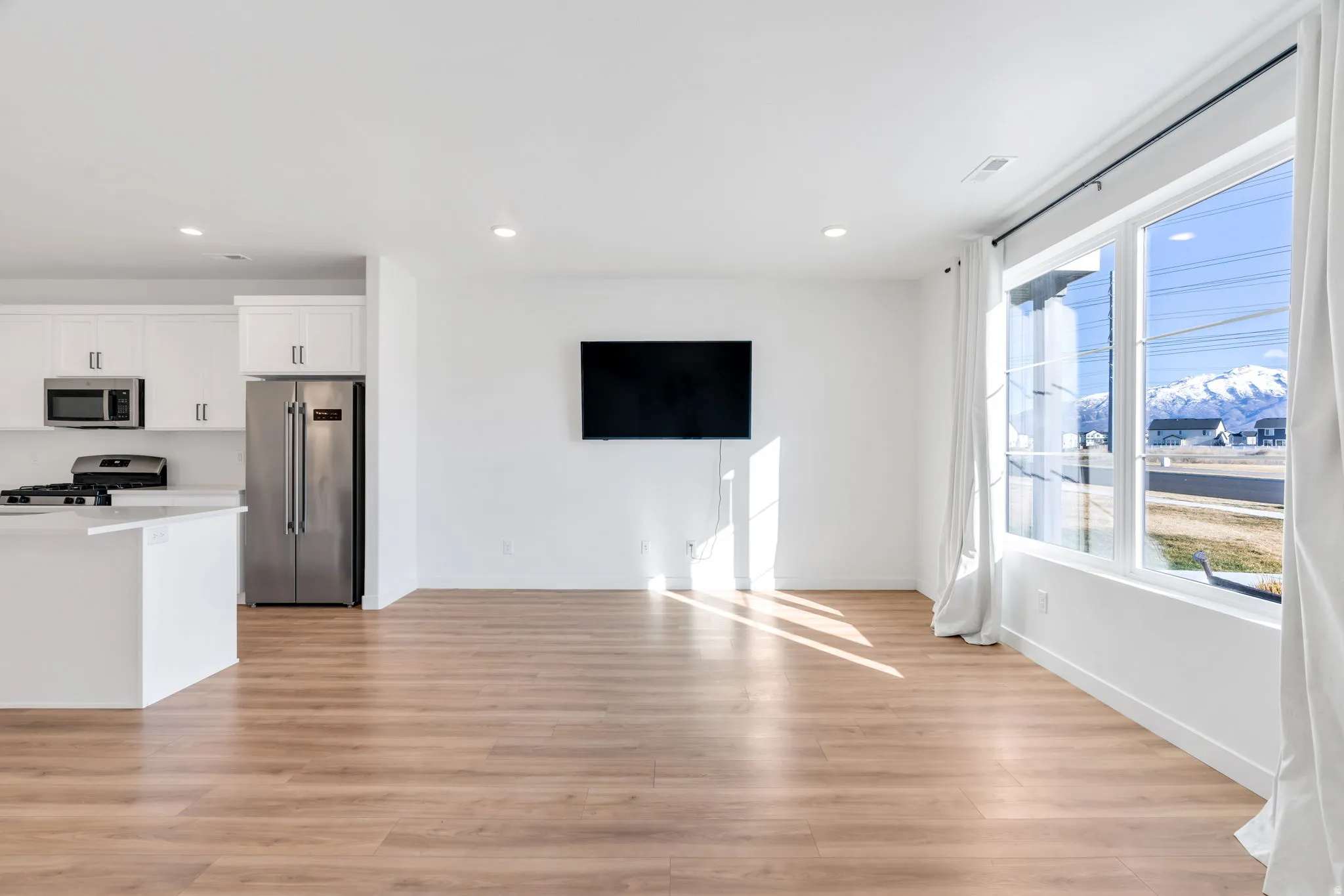 Unfurnished living room with light wood-style flooring and recessed lighting