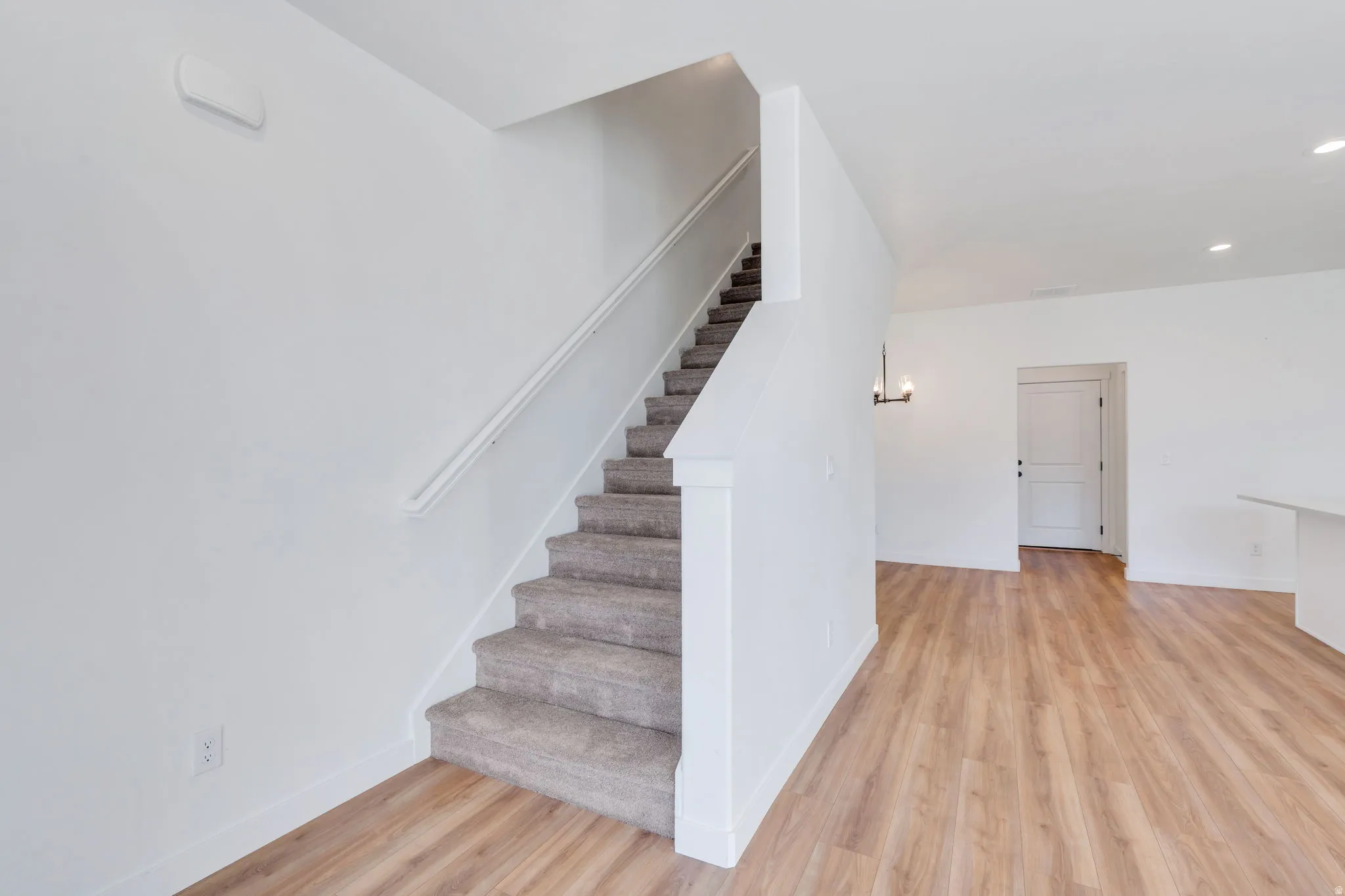 Stairway featuring wood finished floors and recessed lighting