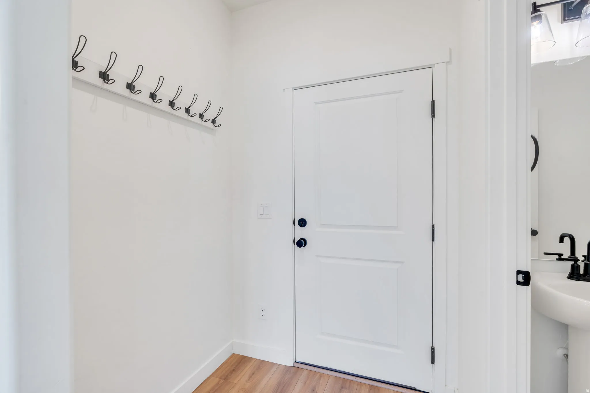 Doorway to outside featuring wood finished floors and baseboards