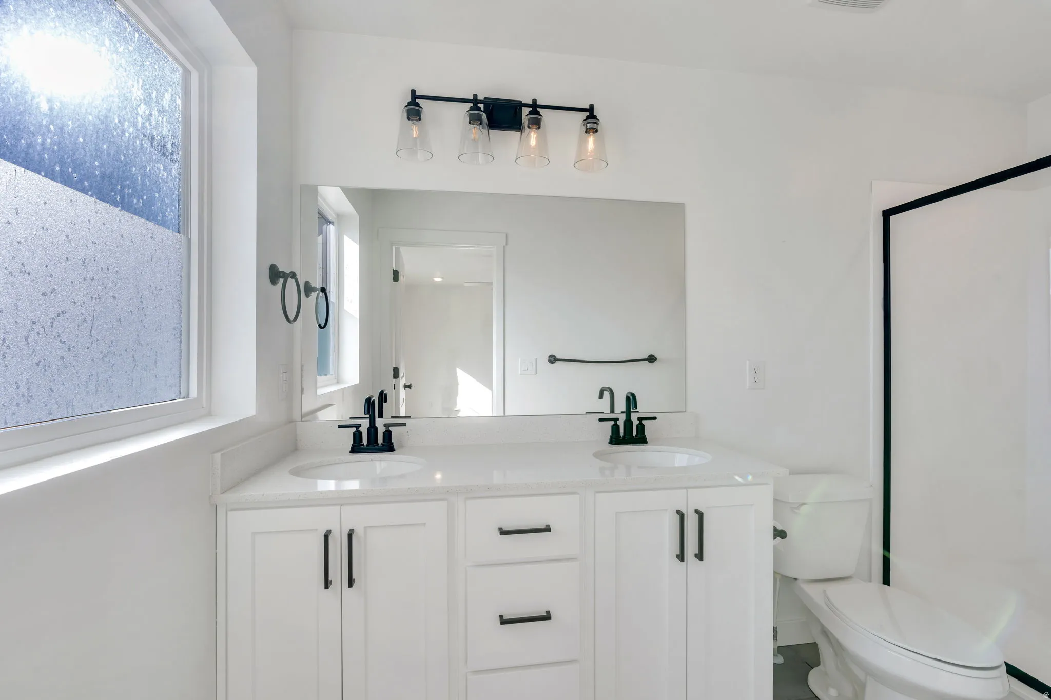 Bathroom featuring double vanity and a shower stall