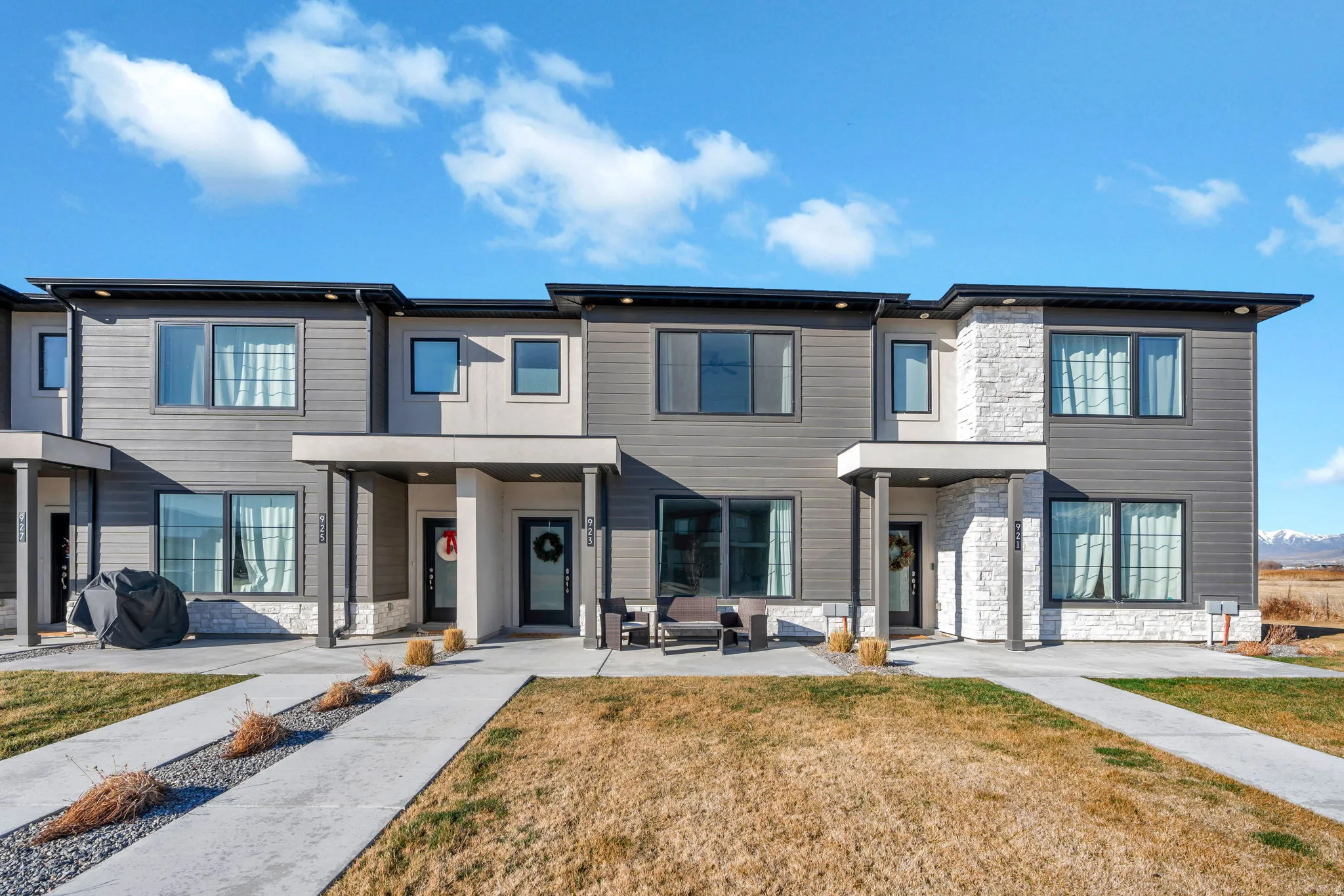 Contemporary home featuring stone siding and a front lawn