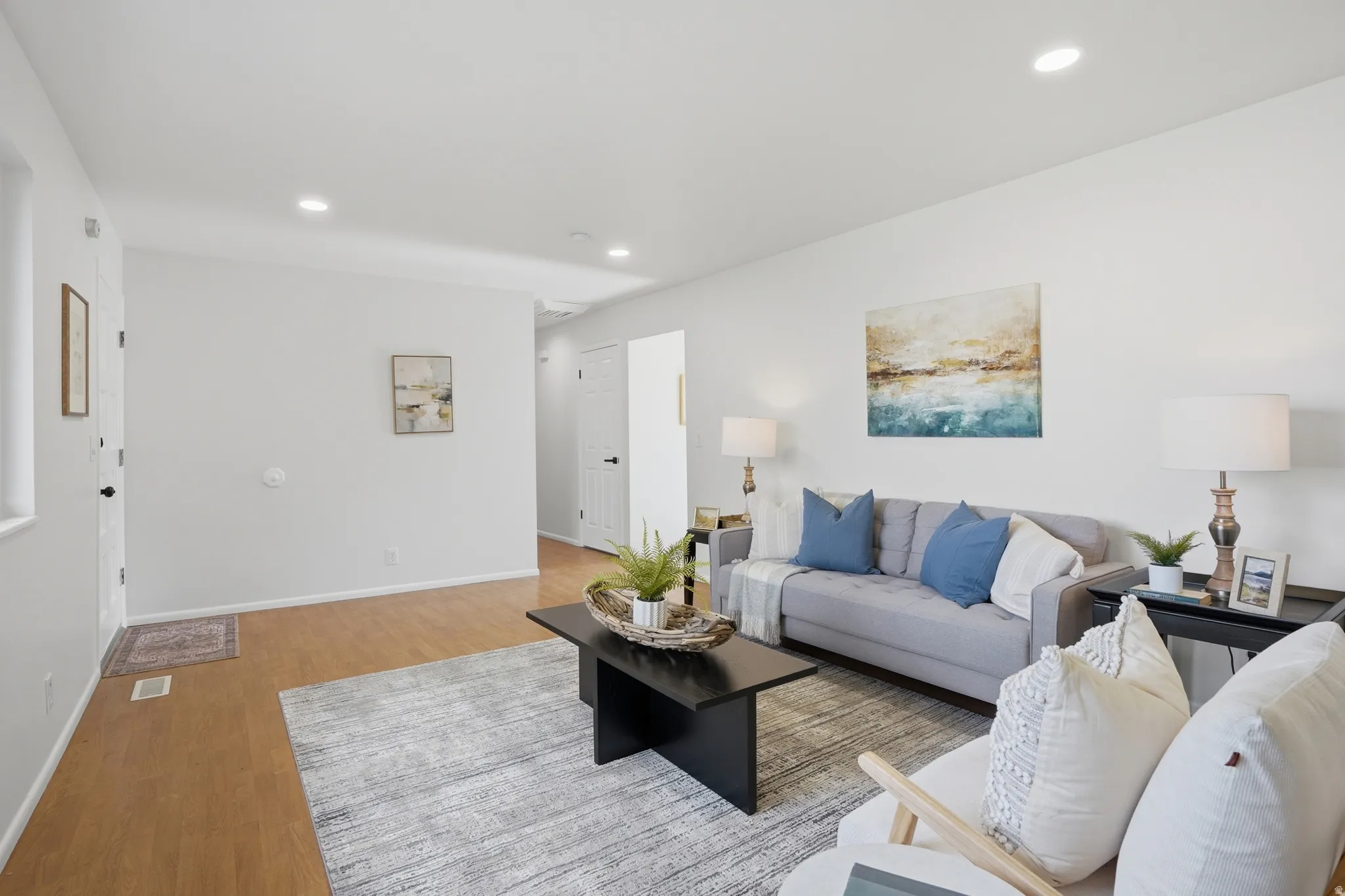 Living room with light wood finished floors and recessed lighting