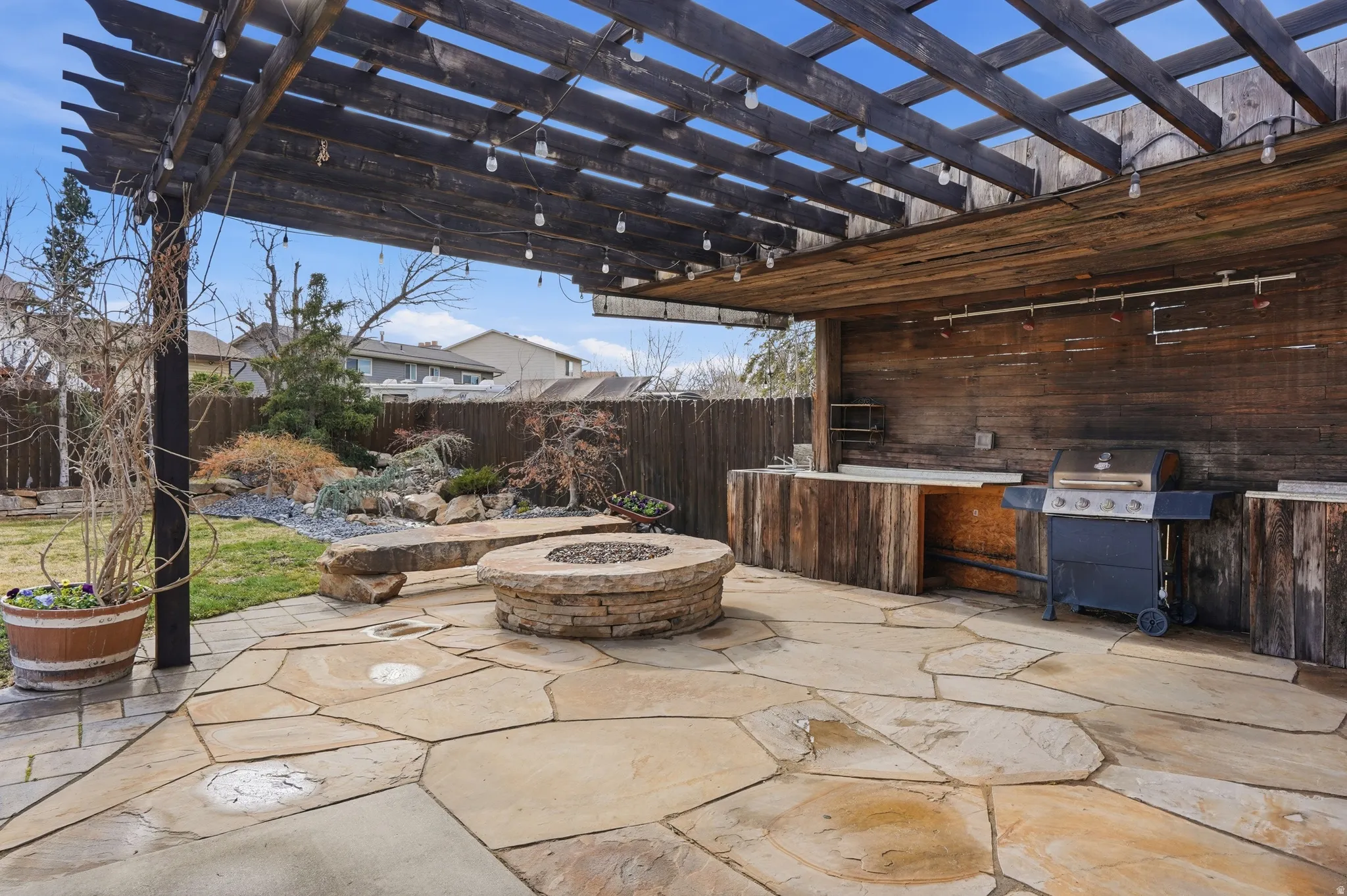 Fenced backyard featuring a pergola, an outdoor fire pit, a patio, and a grill