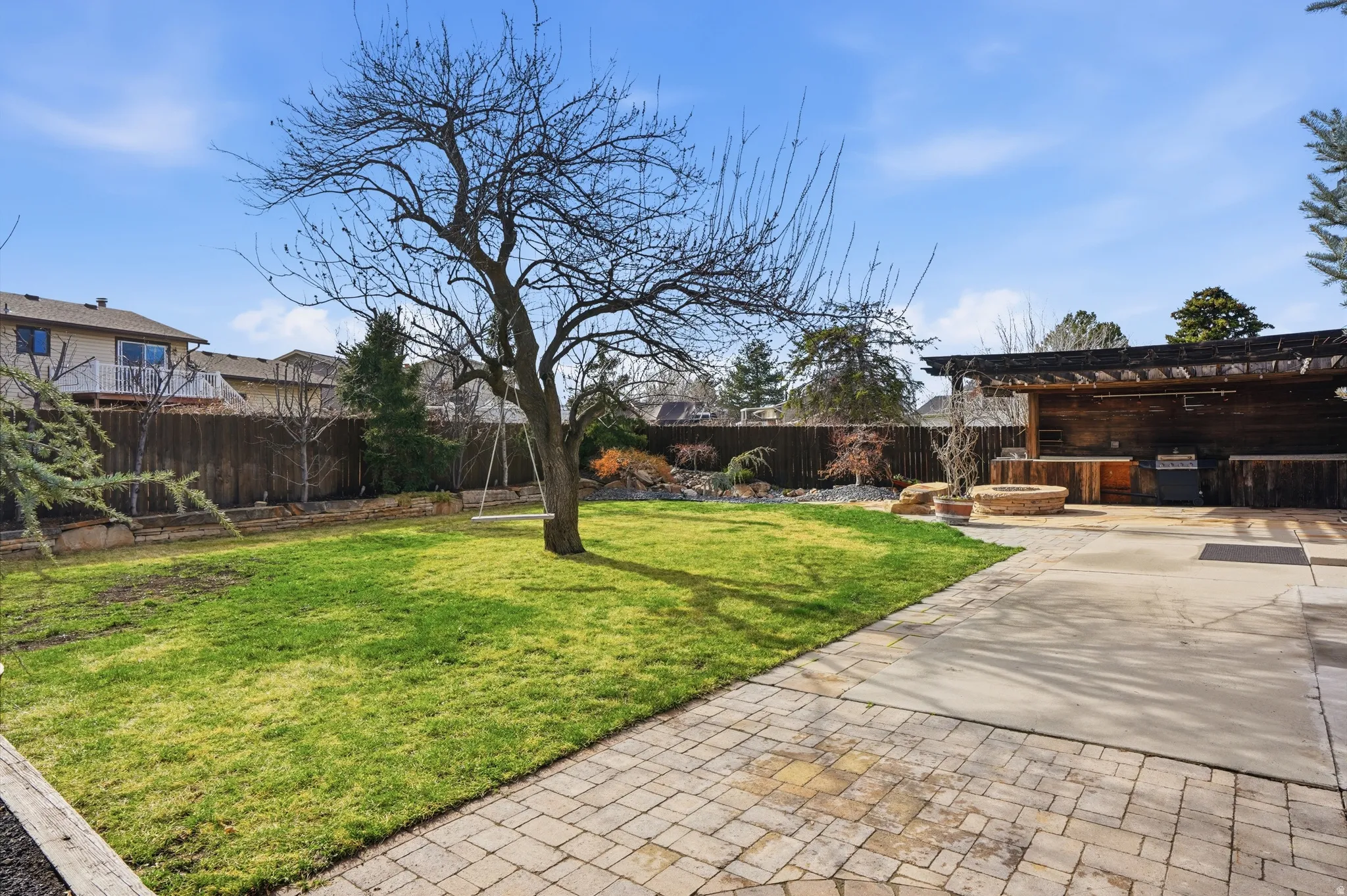 Fenced backyard featuring a patio and area for grilling