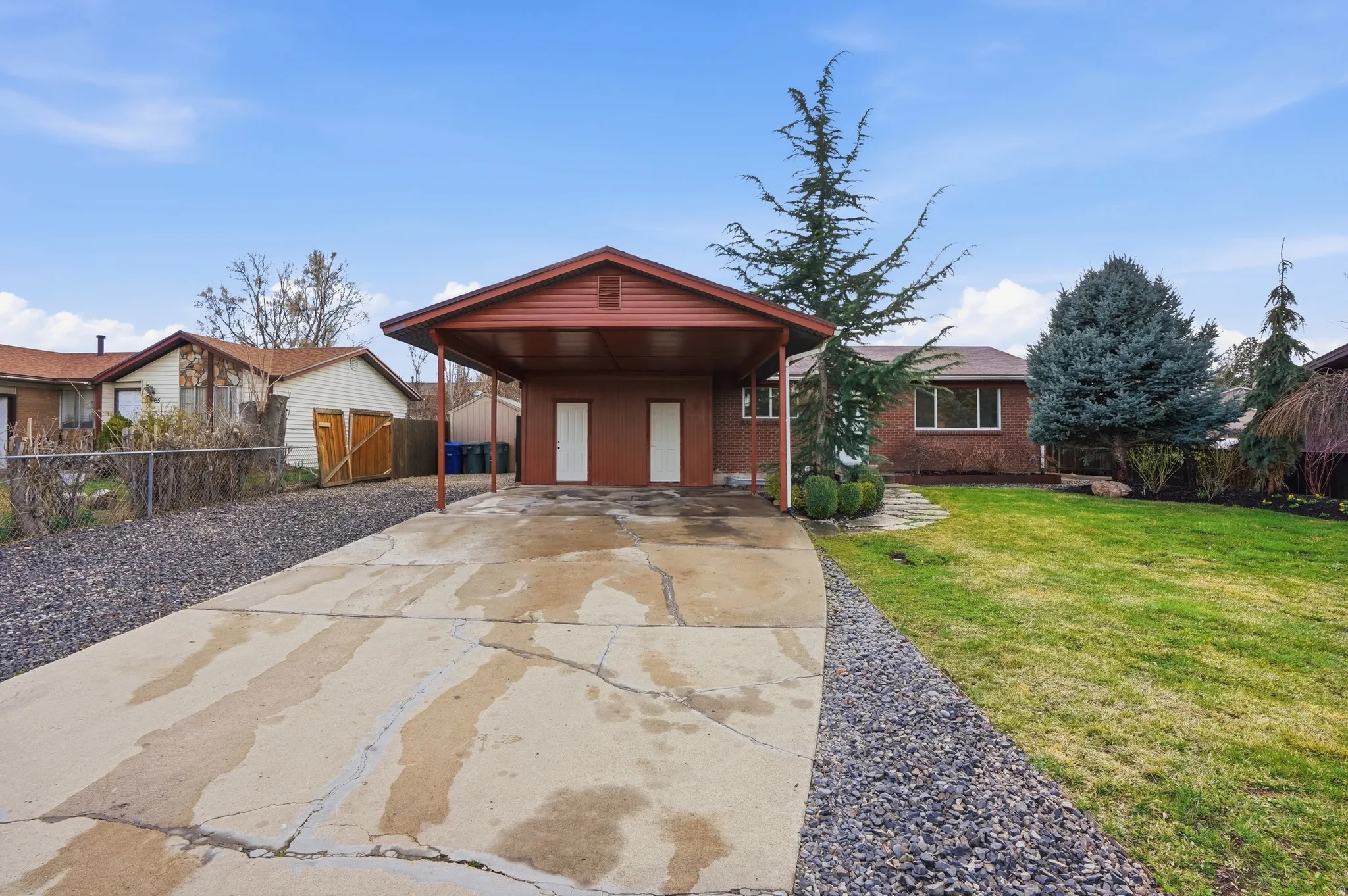 Ranch-style house featuring driveway, a carport, and brick siding