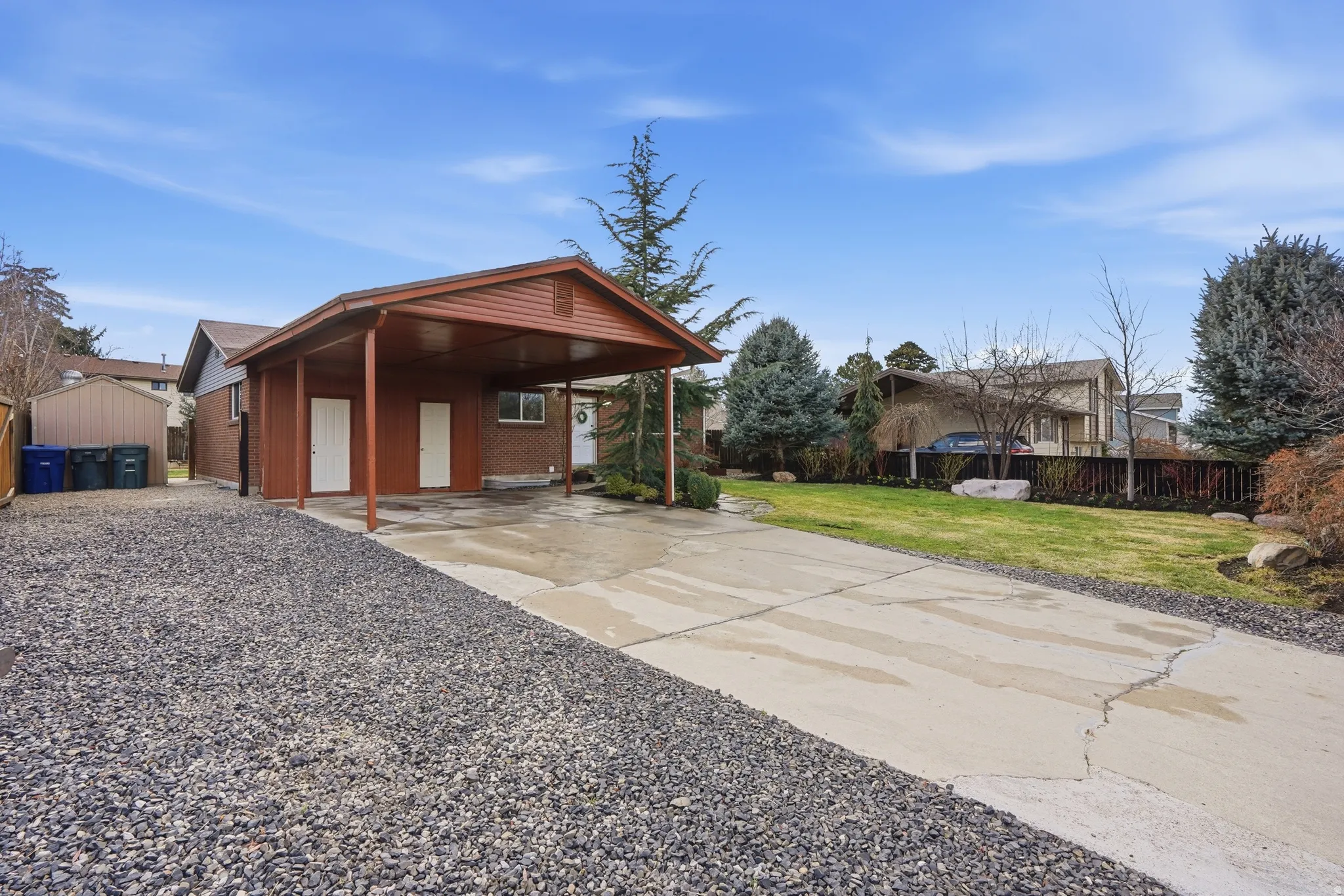 View of front of property with concrete driveway, brick siding, and an attached carport