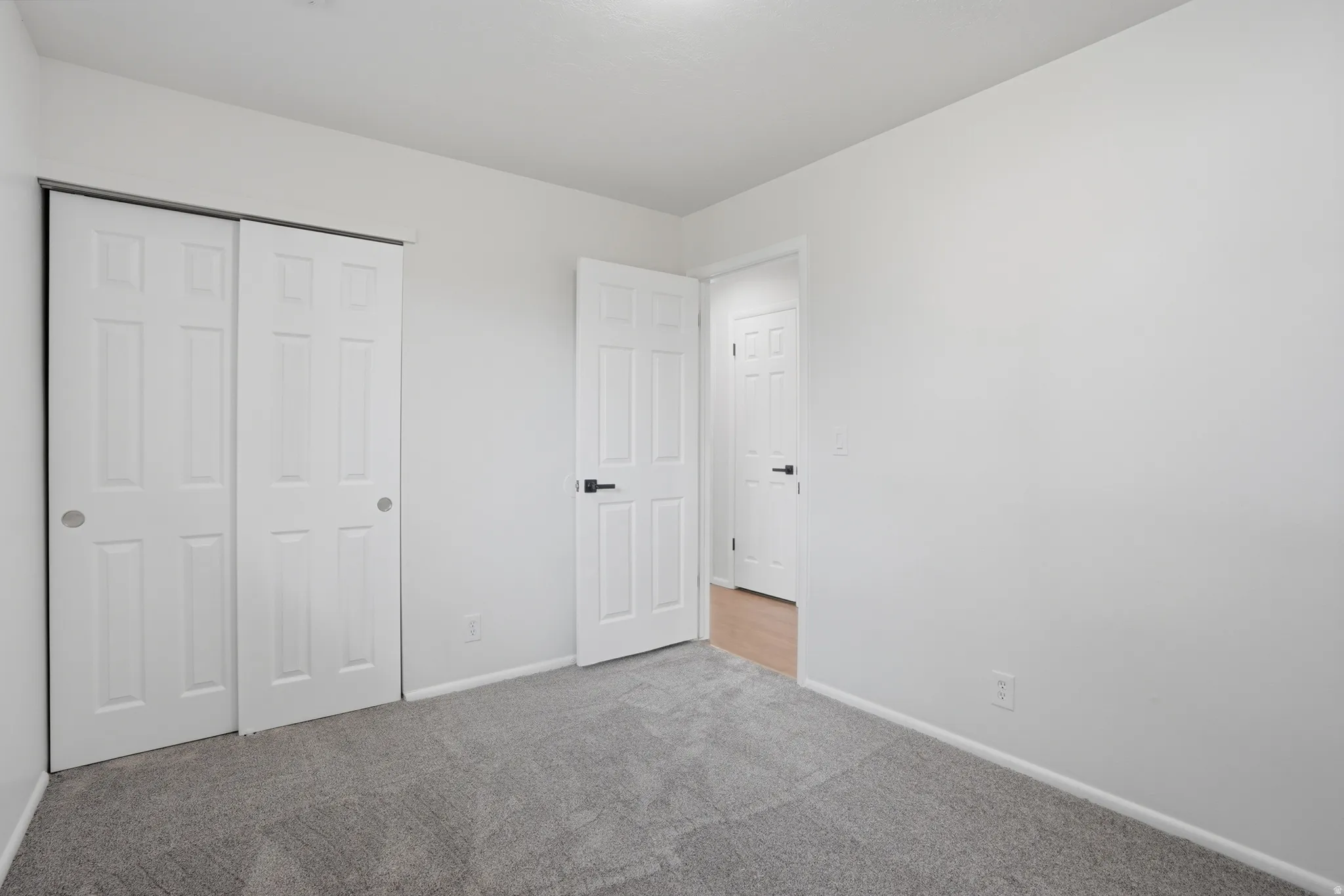 Unfurnished bedroom with light colored carpet and a closet