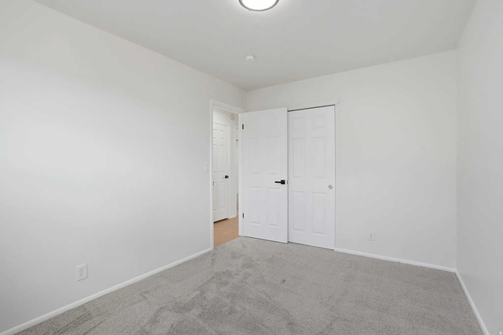 Unfurnished bedroom featuring light colored carpet and a closet