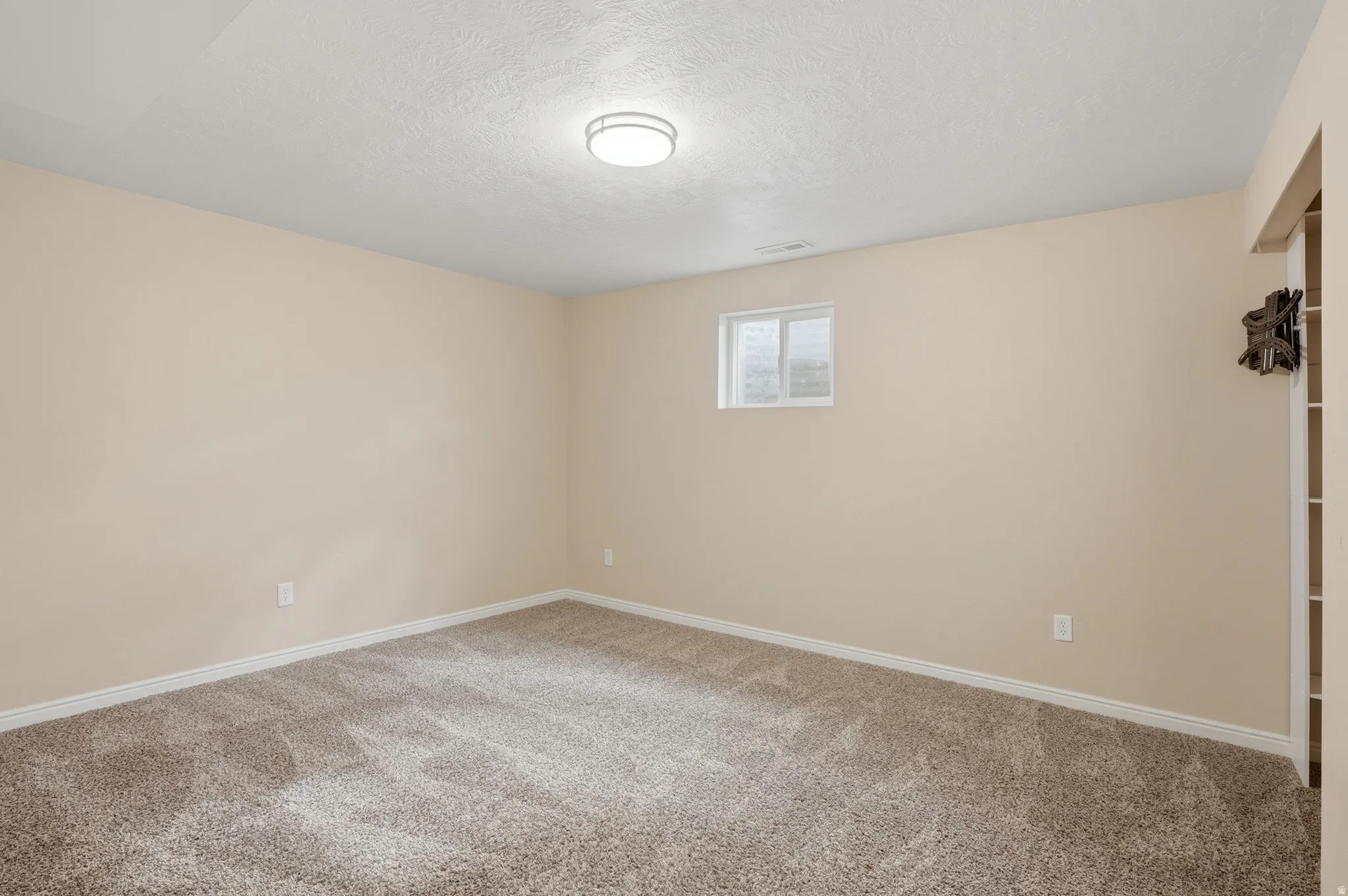 Unfurnished bedroom featuring light carpet and a textured ceiling