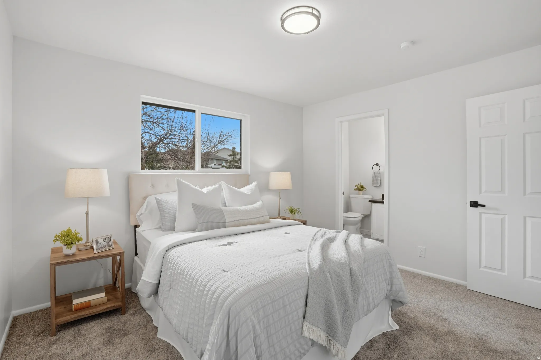Carpeted bedroom featuring baseboards and connected bathroom