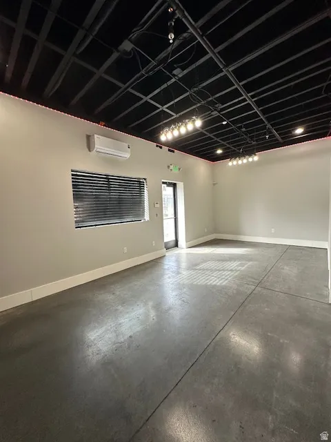Unfurnished room with finished concrete flooring and a mini split for heating / cooling