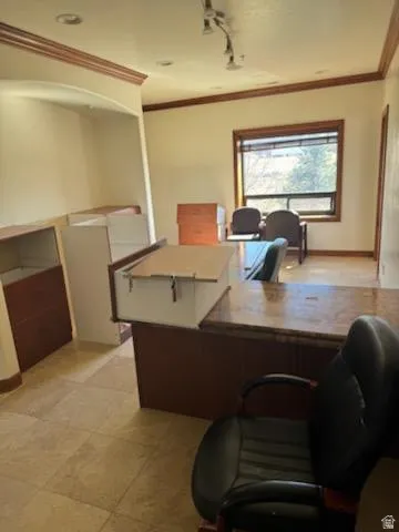 Office area featuring ornamental molding and track lighting