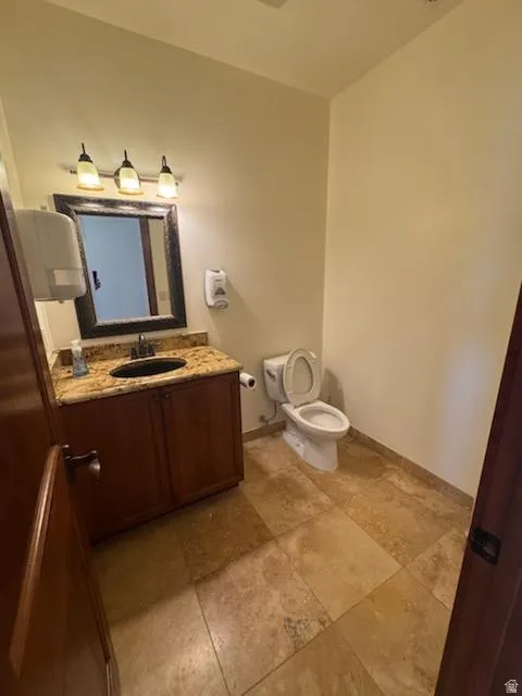 Half bathroom featuring vanity and toilet