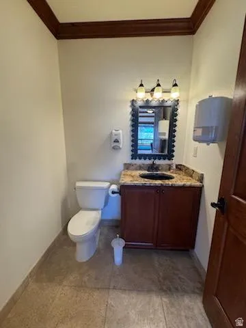 Half bath featuring vanity and ornamental molding