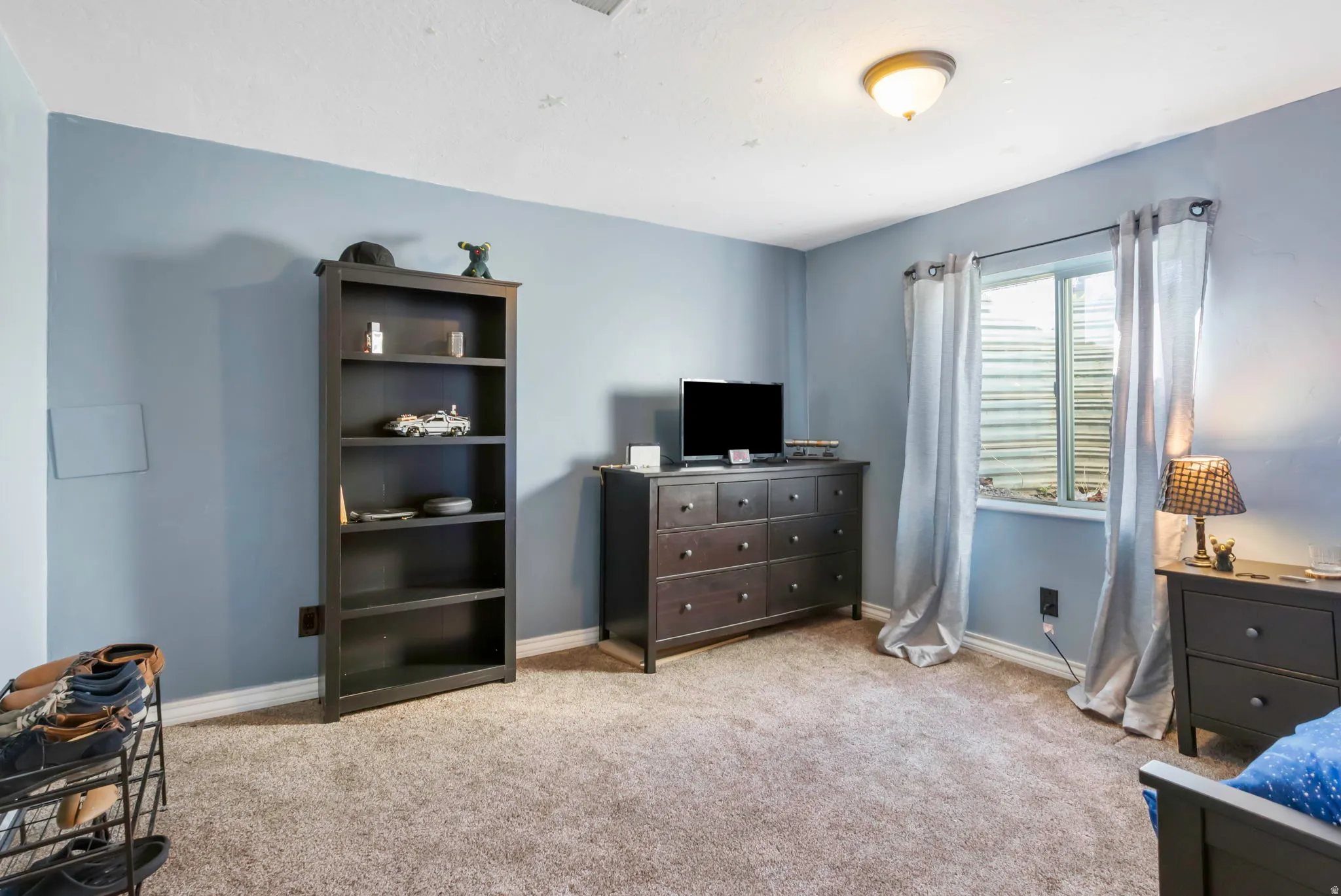 Bedroom featuring light carpet and baseboards