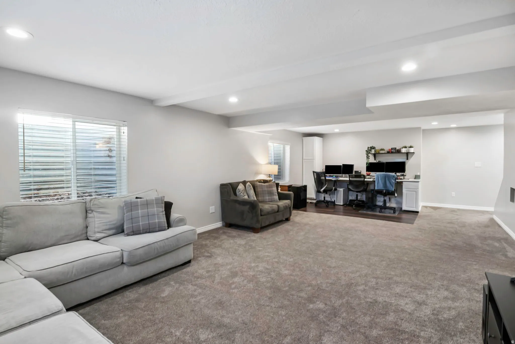 Living area with an office area, dark carpet, recessed lighting, and beamed ceiling