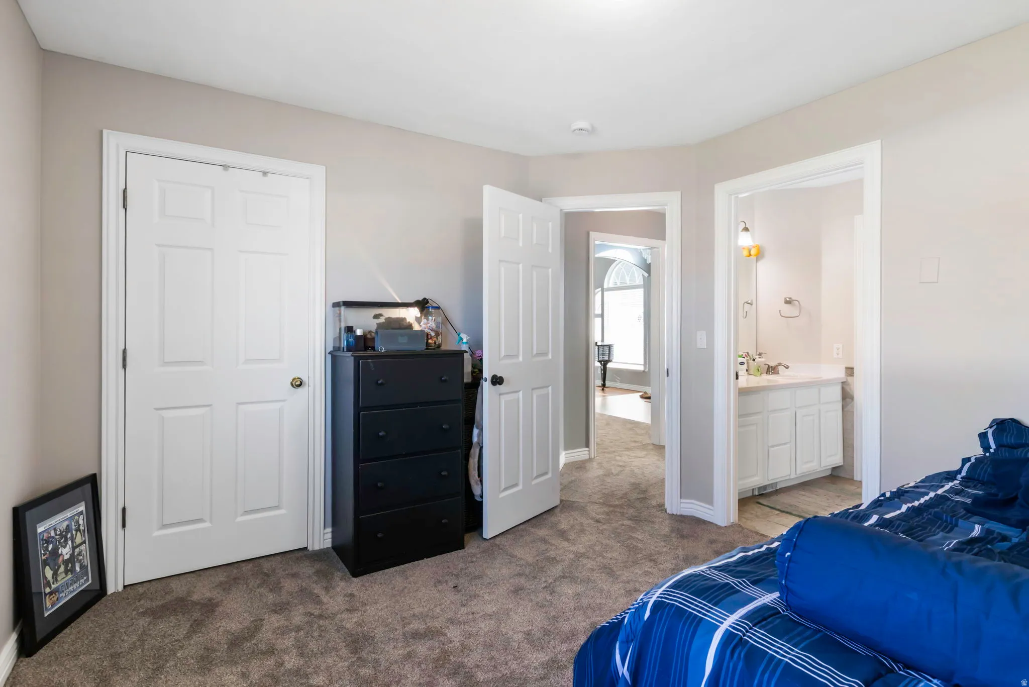 Bedroom featuring light colored carpet and ensuite bath