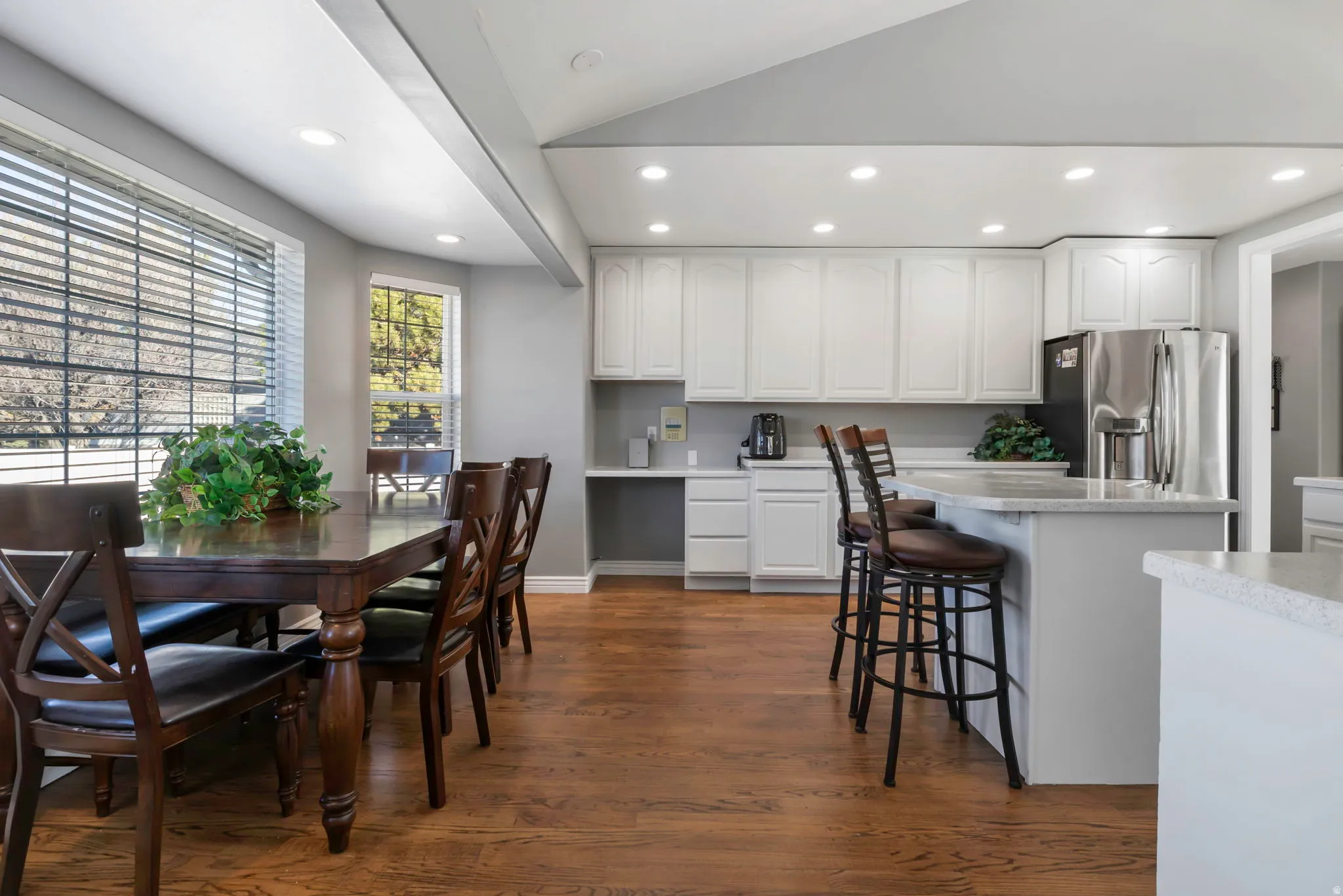 Kitchen with recessed lighting, white cabinets, dark wood finished floors, stainless steel fridge, and light countertops