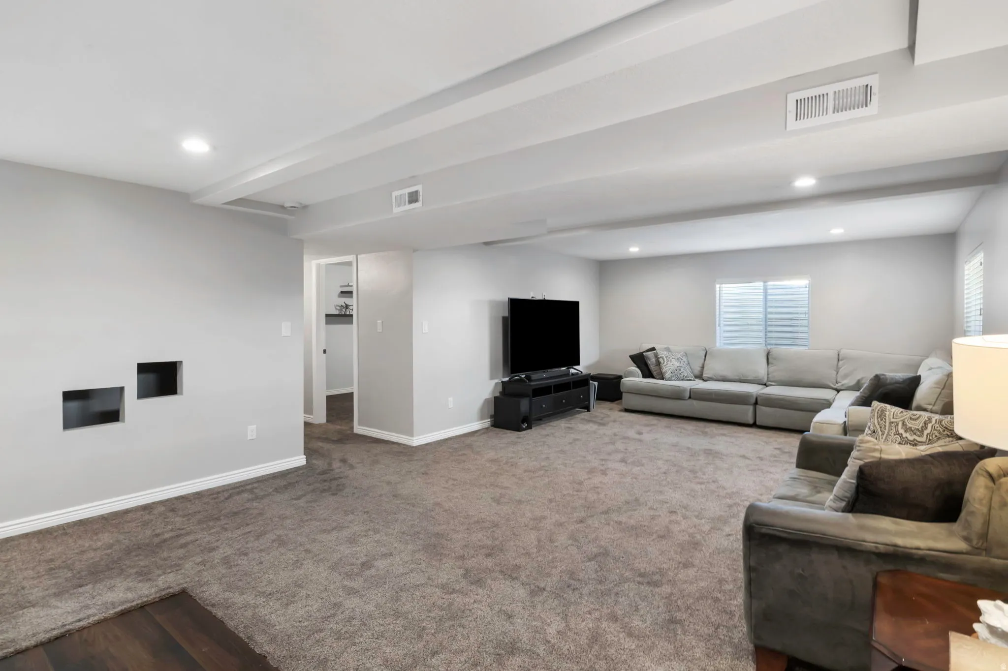 Carpeted living room featuring recessed lighting and baseboards