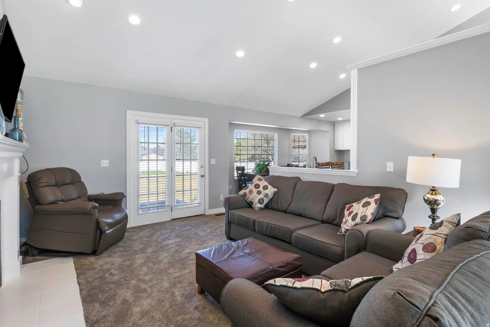 Living room with vaulted ceiling, recessed lighting, carpet floors, and a fireplace