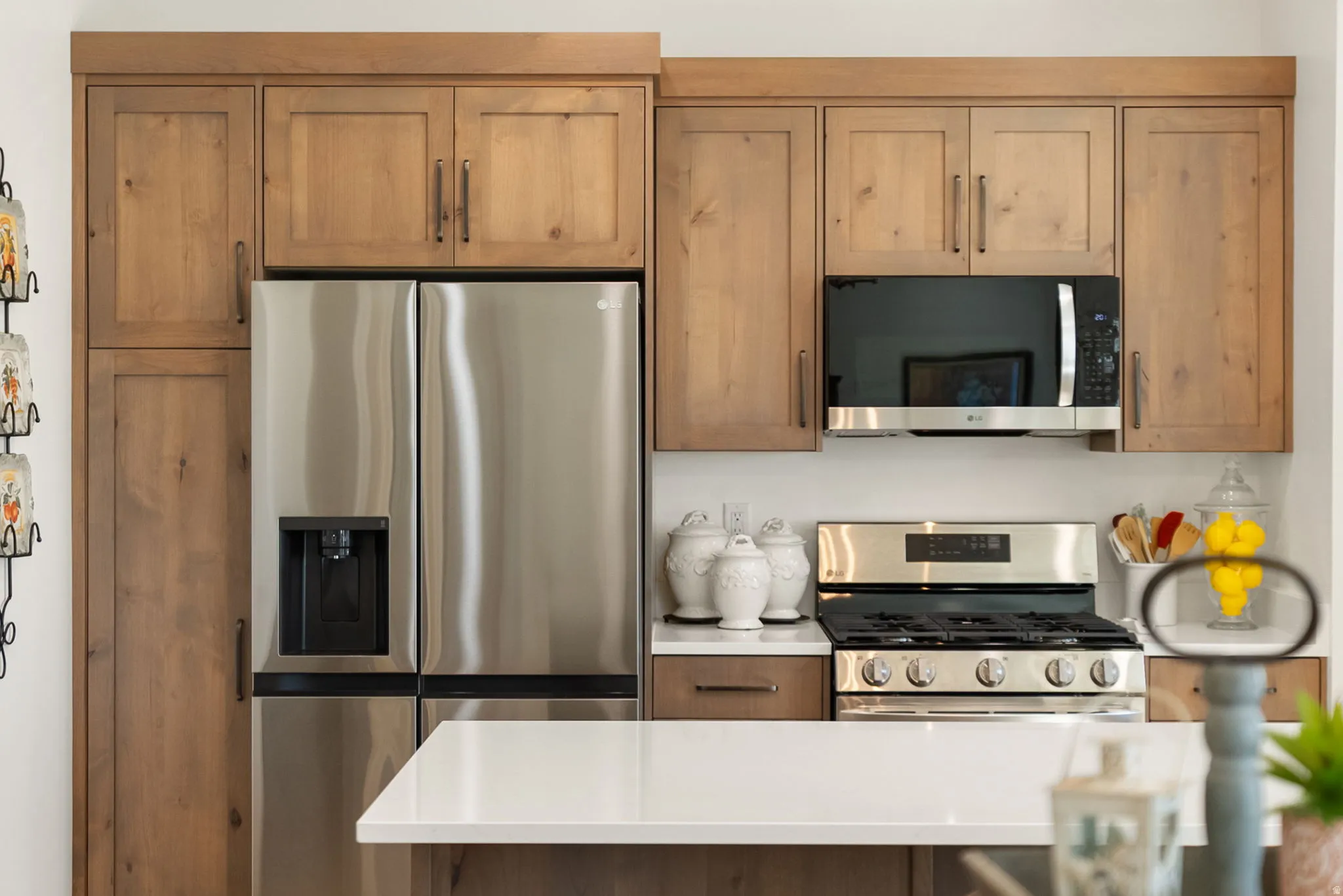 Kitchen with stainless steel appliances, light countertops, and wood finish cabinets
